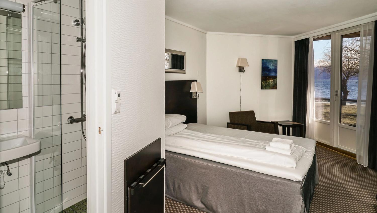 Hotellrom med enkeltseng og flott utsikt mot fjorden frå vindauget.