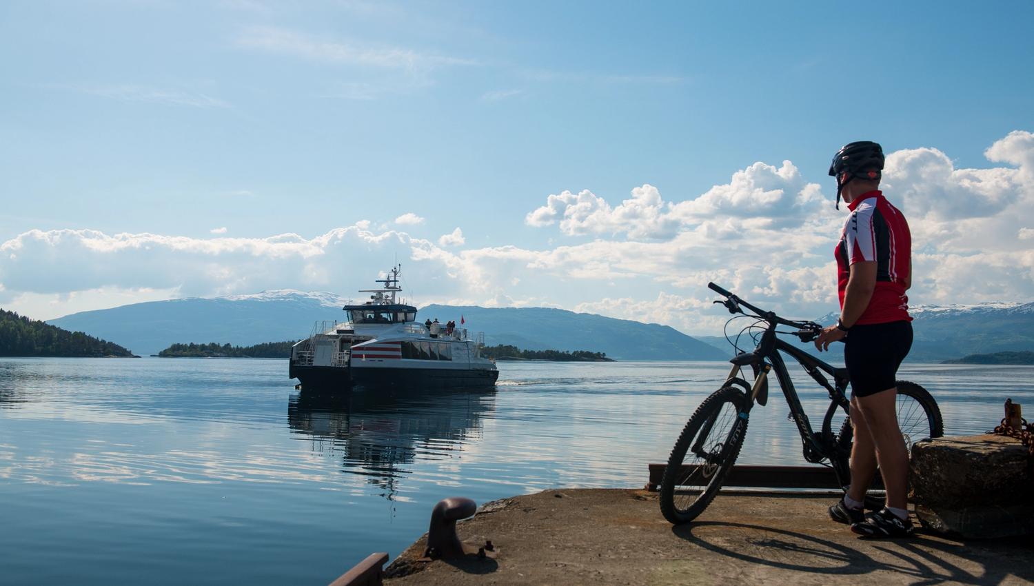 Syklist ventar på sightseeing-båten i Herand i Hardanger.