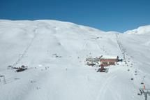 Main lodge and ski lifts at Røldal Ski Resort surrounded by snow-covered mountains.