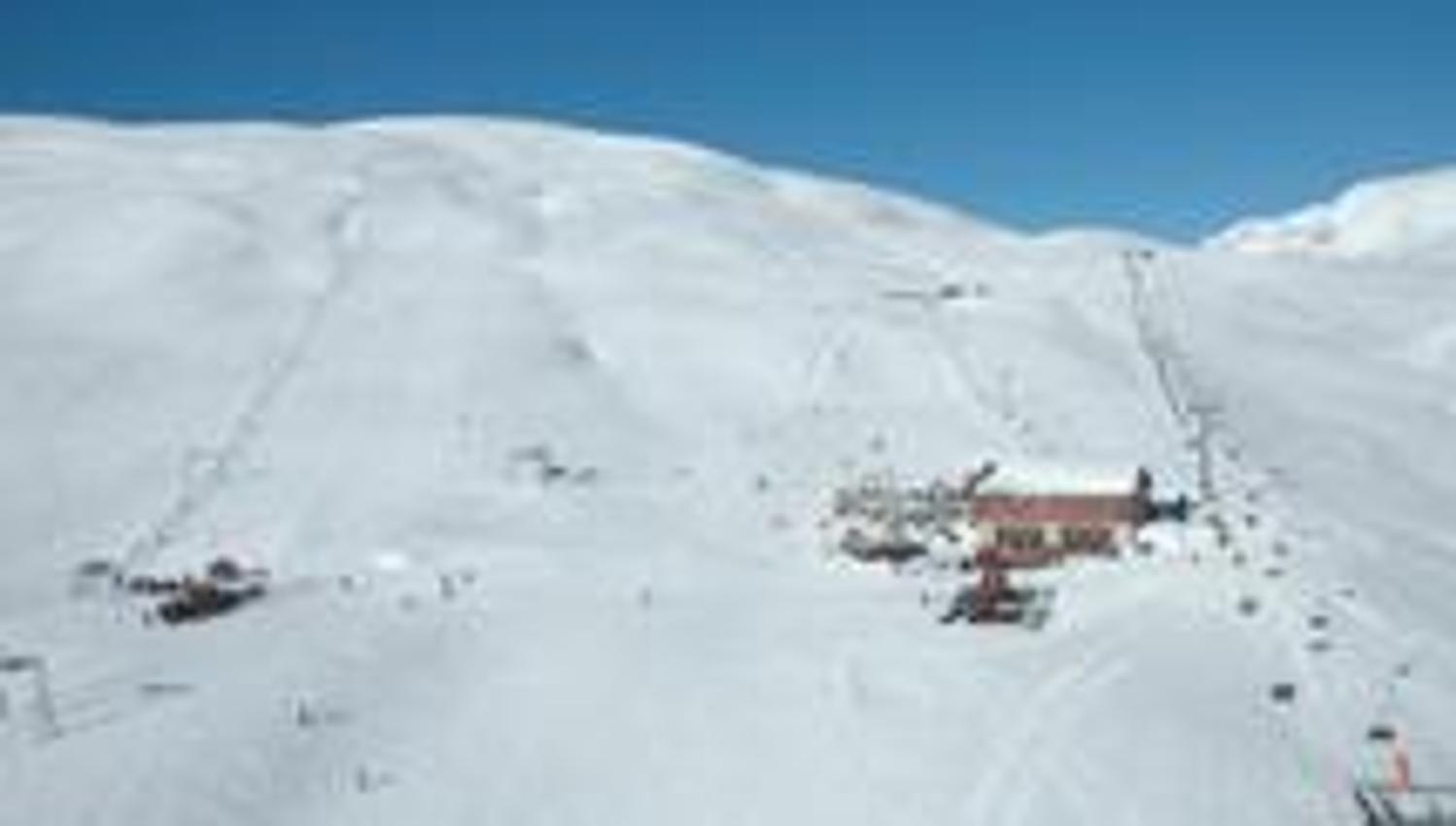 Main lodge and ski lifts at Røldal Ski Resort surrounded by snow-covered mountains.
