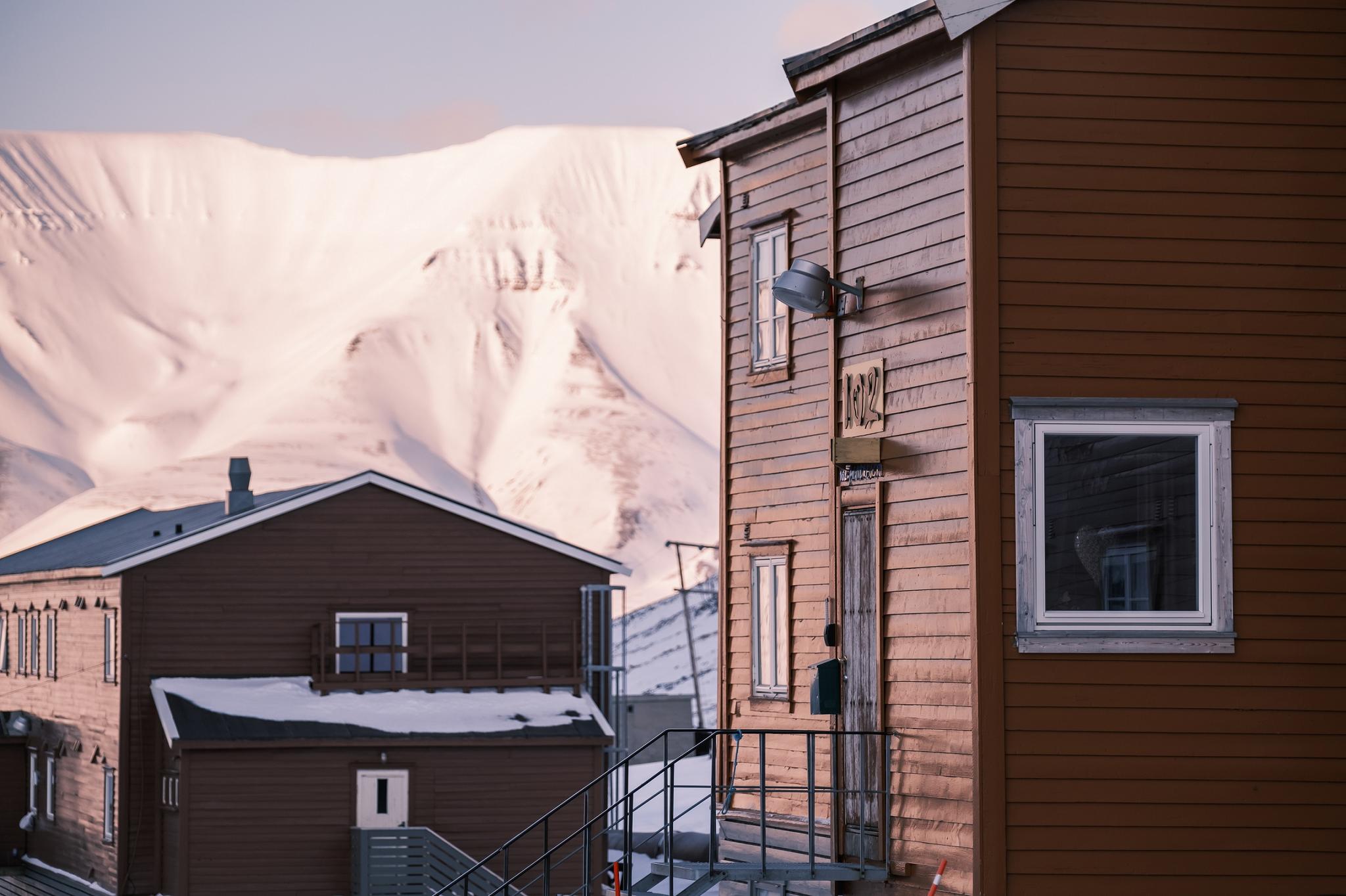 The guesthouse in the foreground with another building and a mountain in the background