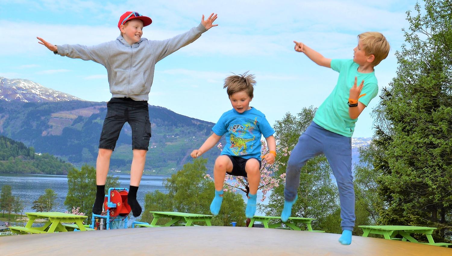 Kids jumping and having fun on the trampoline with fjord views at Mikkelparken