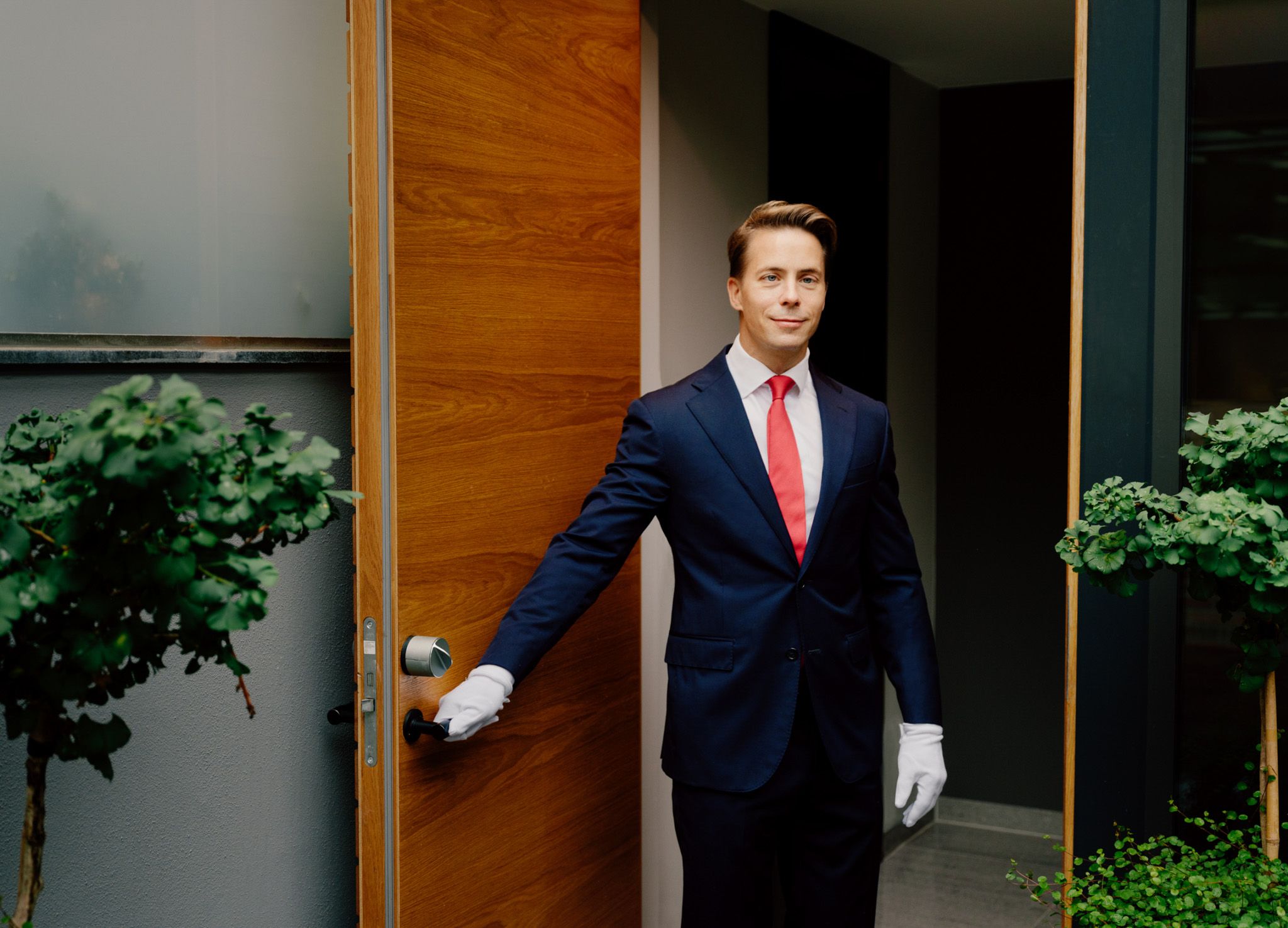 Male butler holding the door open