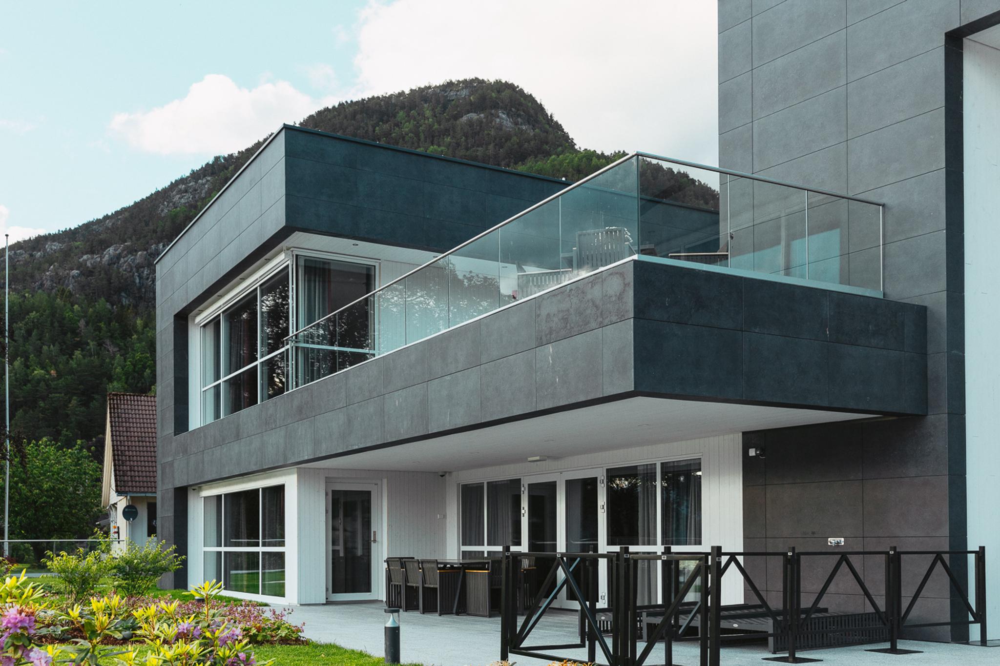 Modern facade of Hardanger House with spacious balcony and fjord view.