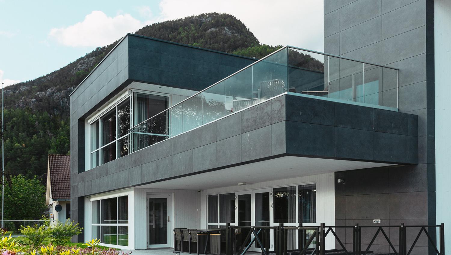 Modern facade of Hardanger House with spacious balcony and fjord view.