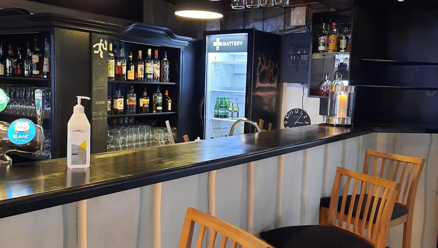 A bar with wine glasses from the ceiling.