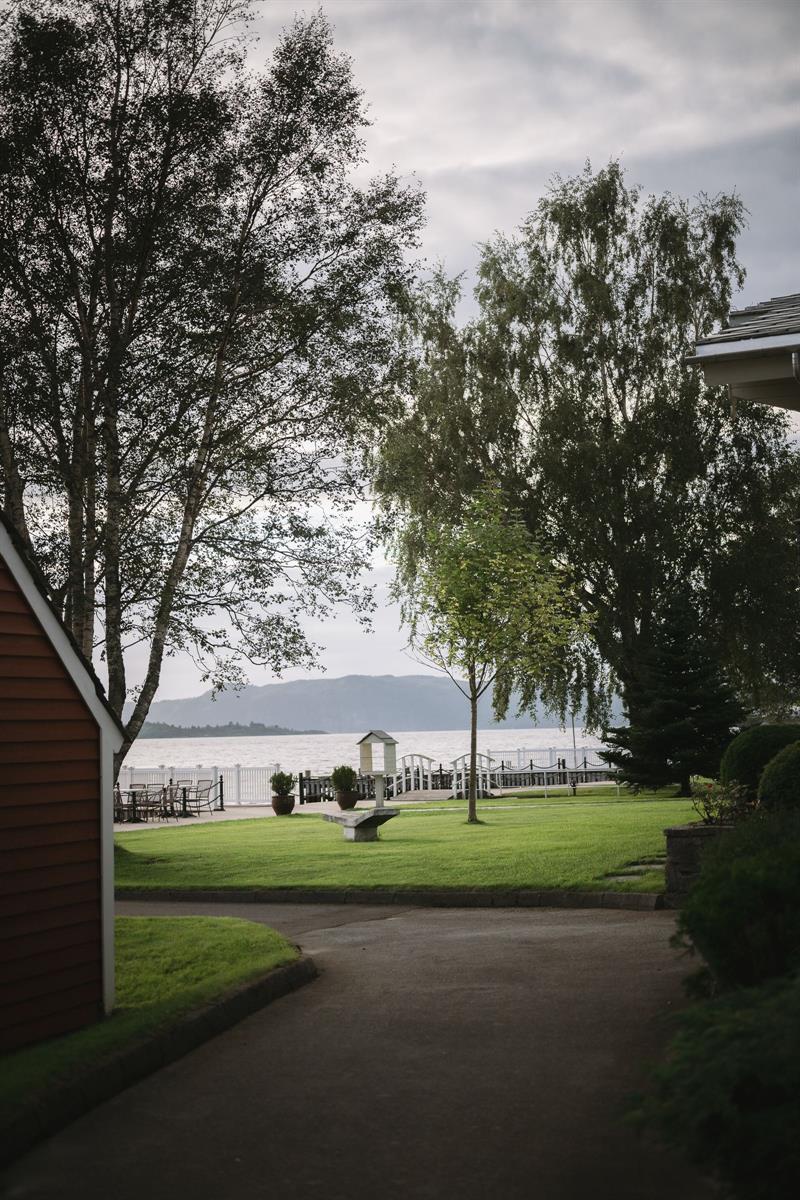 Hageområdet ved Rosendal Fjordhotel med utsikt mot hardangerfjorden og fjell