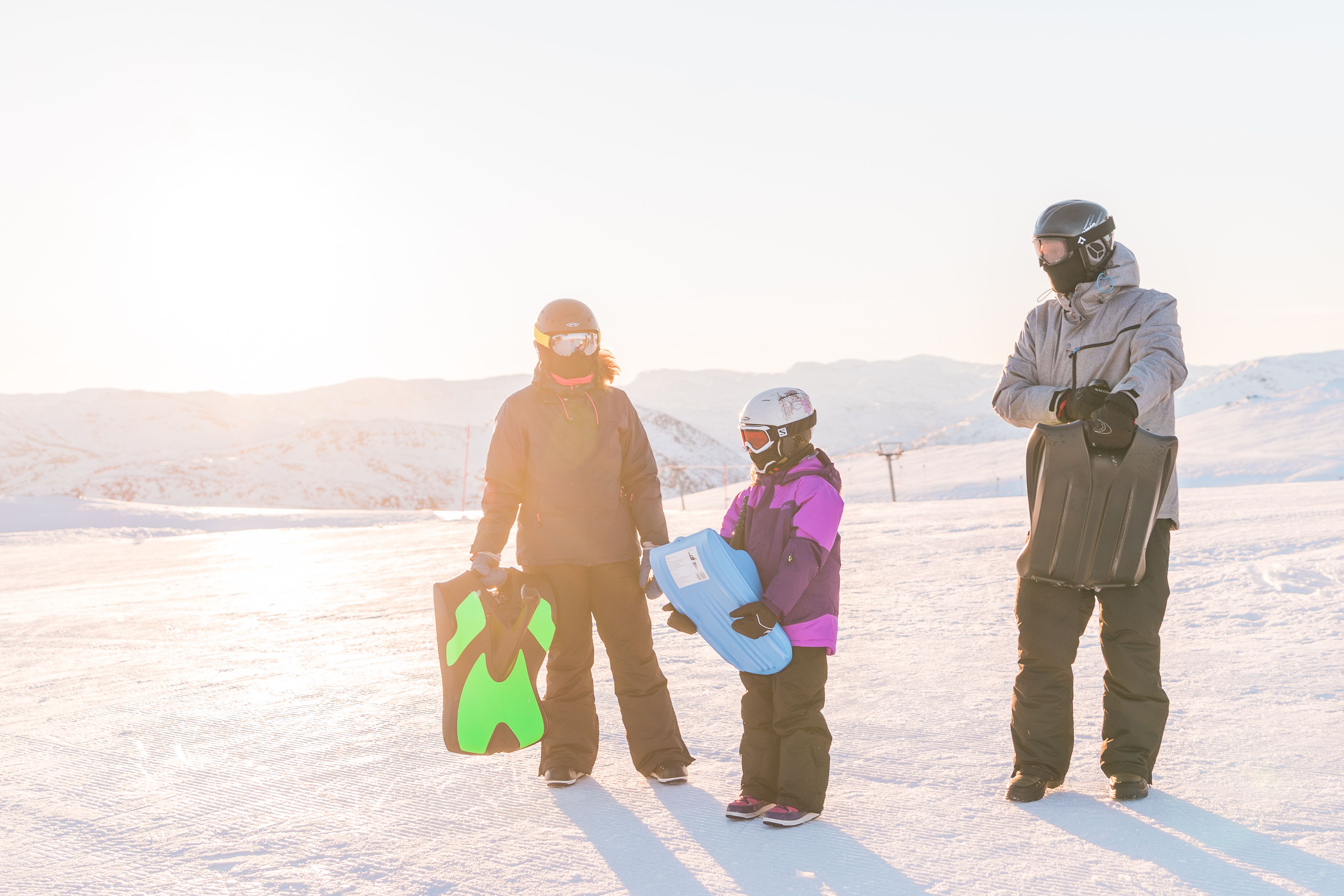 Familie på tre bærer på hvert sitt akebrett, bilde