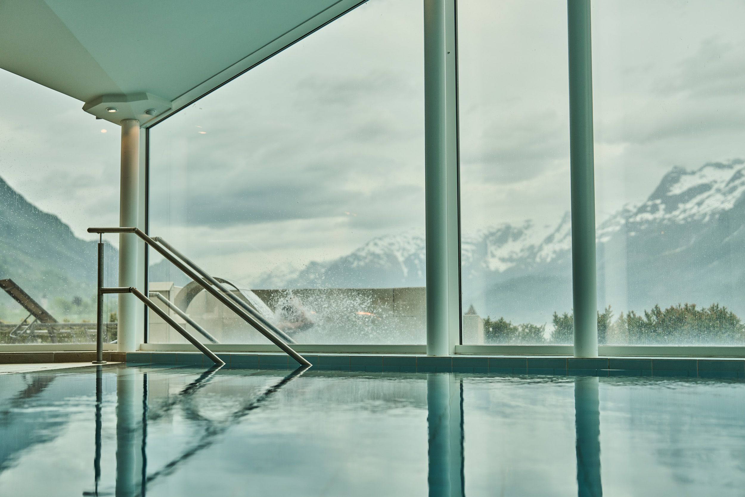 Innandørs basseng med panoramautsikt mot fjell og fjord på Hotel Ullensvang.