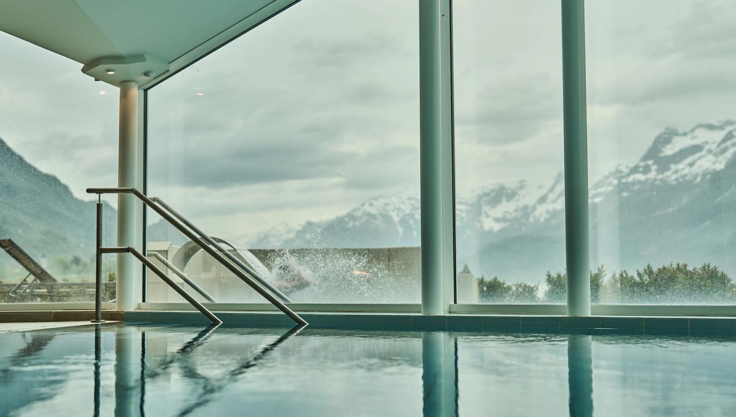 Innandørs basseng med panoramautsikt mot fjell og fjord på Hotel Ullensvang.