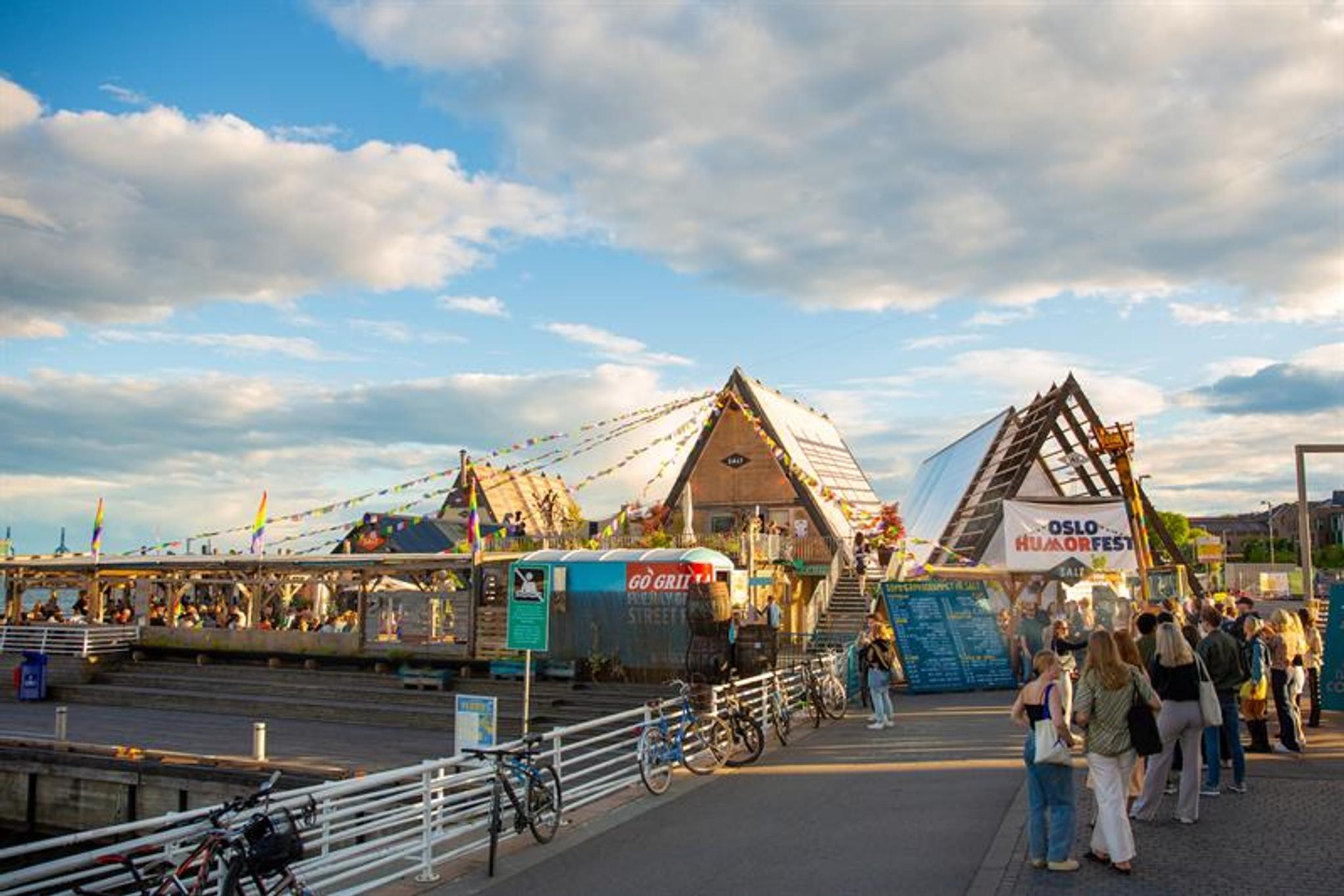 Mennesker som står i kø utenfor SALT på en fin sommerdag