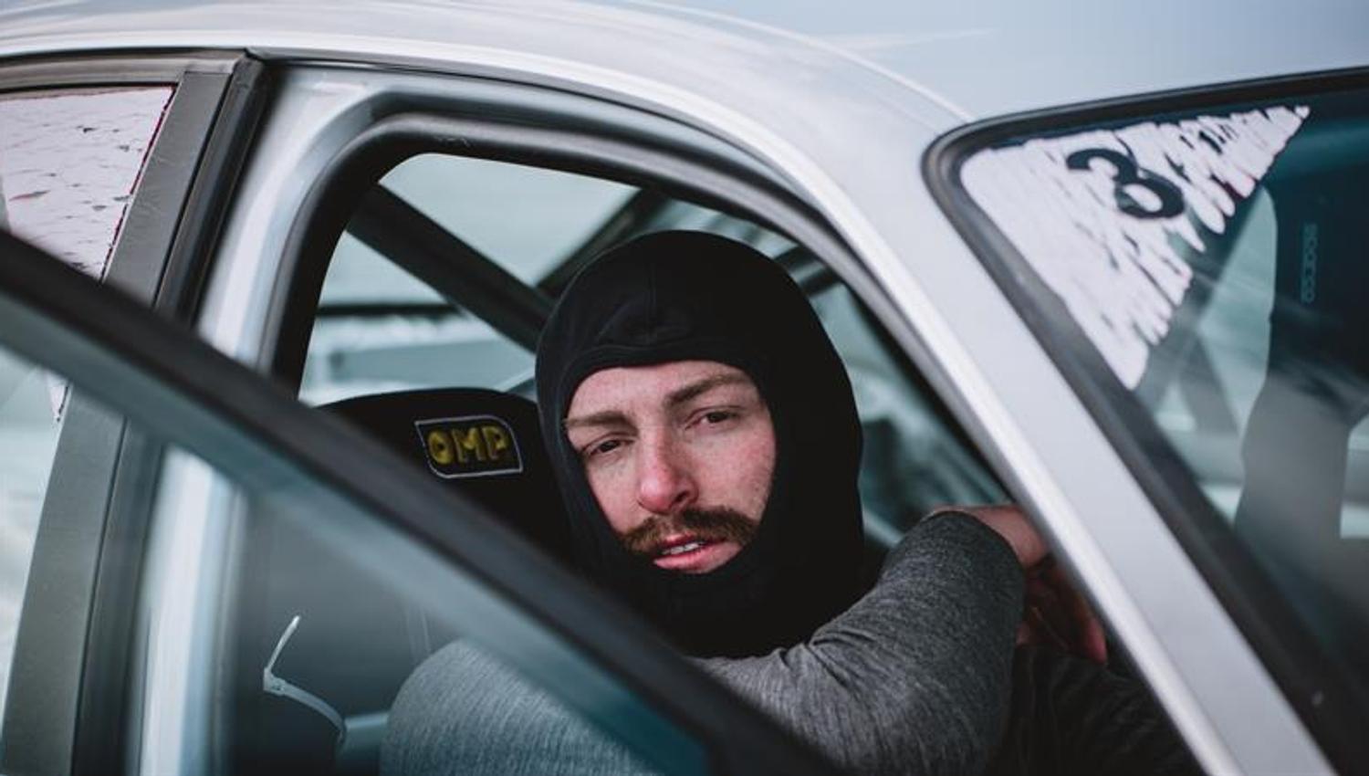 A driver is sitting in the car after an extreme rally experience.