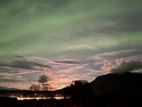 Strong contrast between the mountains, sky, clouds and Aurora