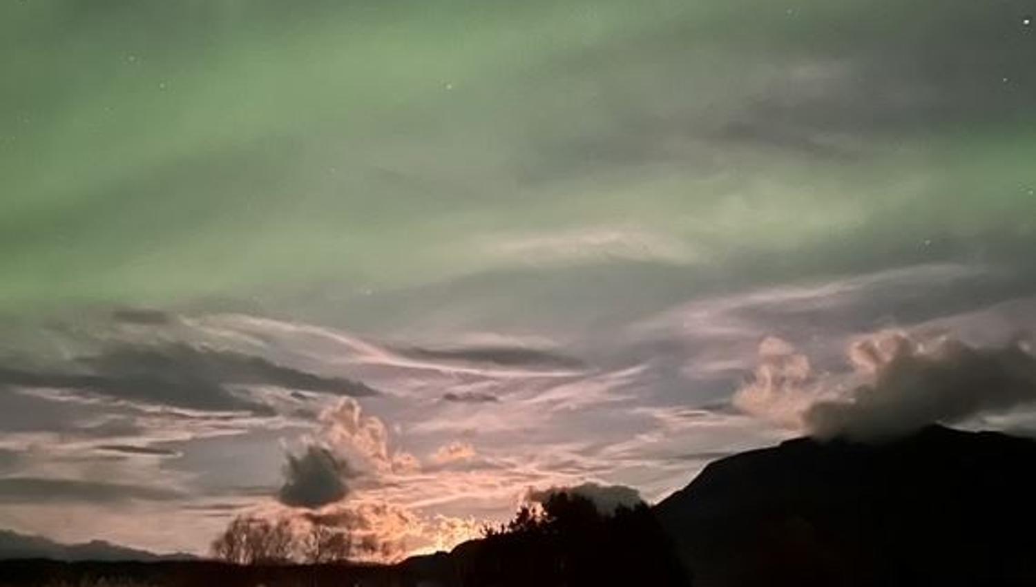 Strong contrast between the mountains, sky, clouds and Aurora