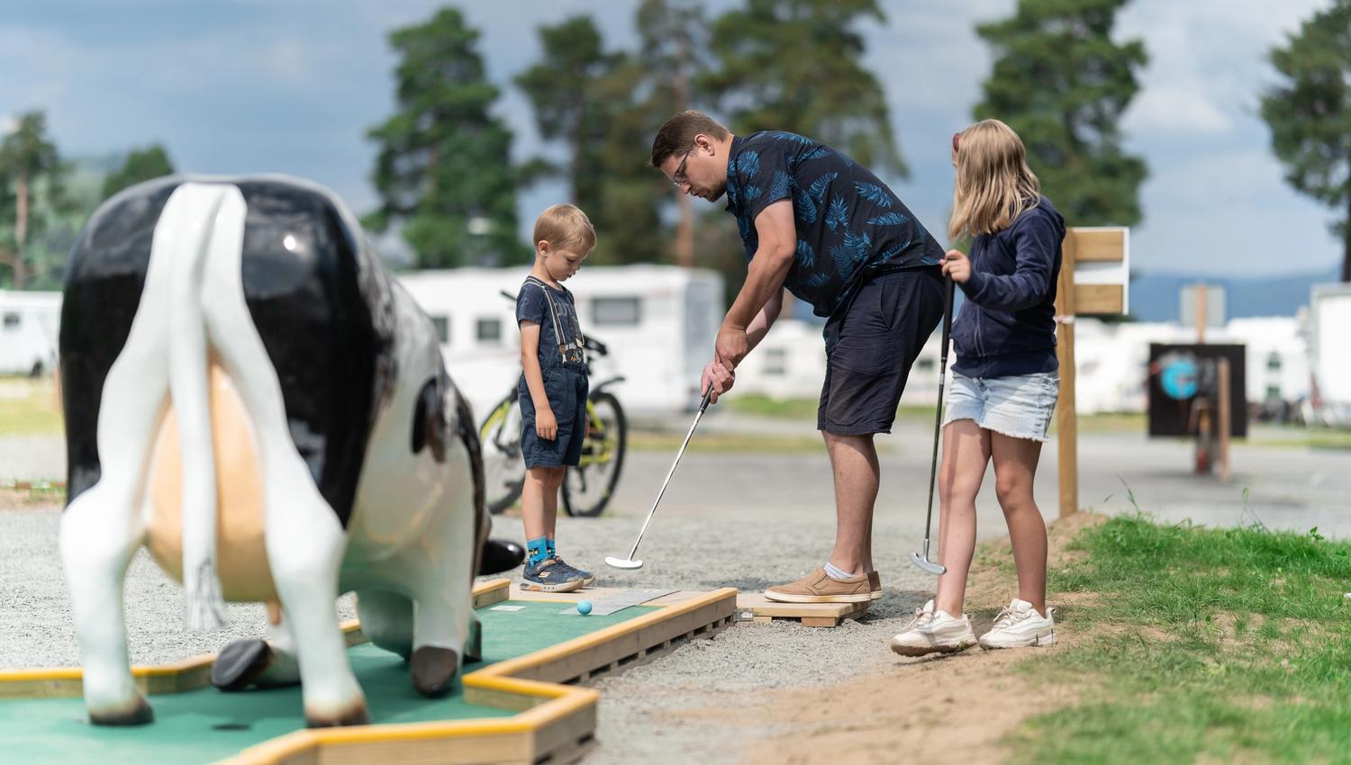 Familie spiller minigolf på Sveastranda Camping