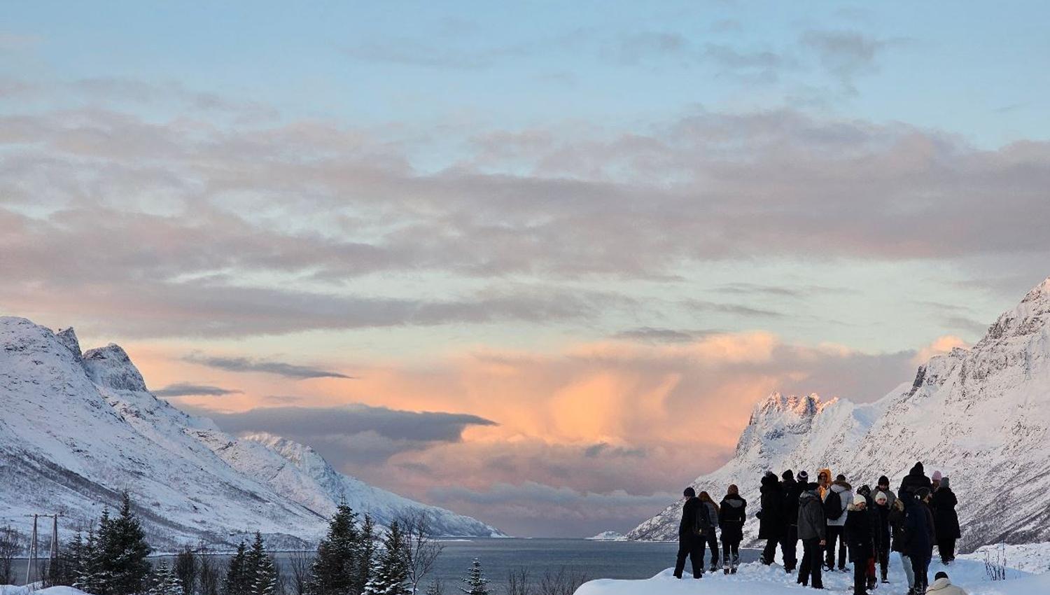Gjester ser ut på en fjord