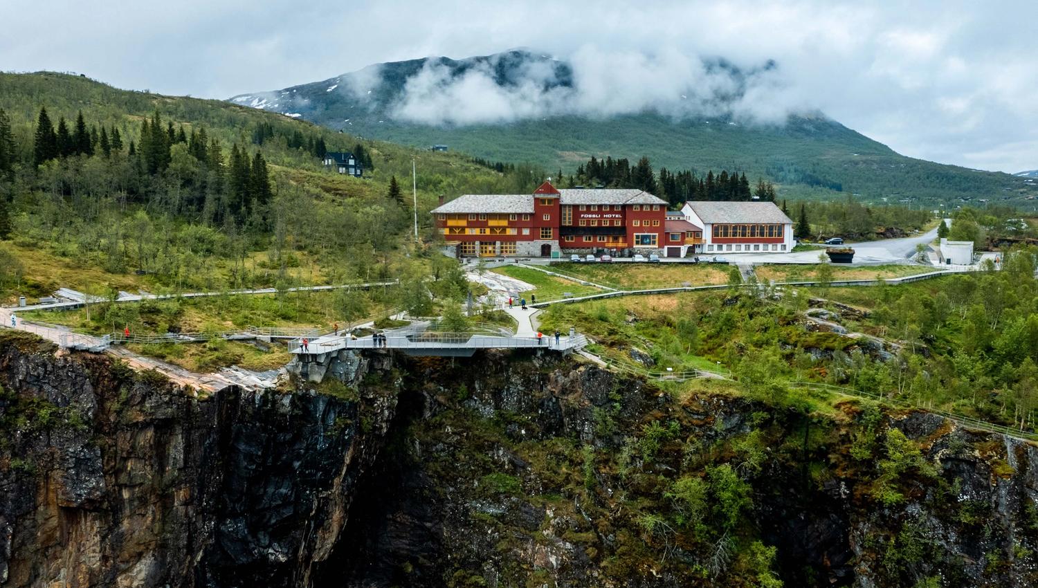 Et dronebilde av Fossli Hotel som ligger rett ovenfor fossen.