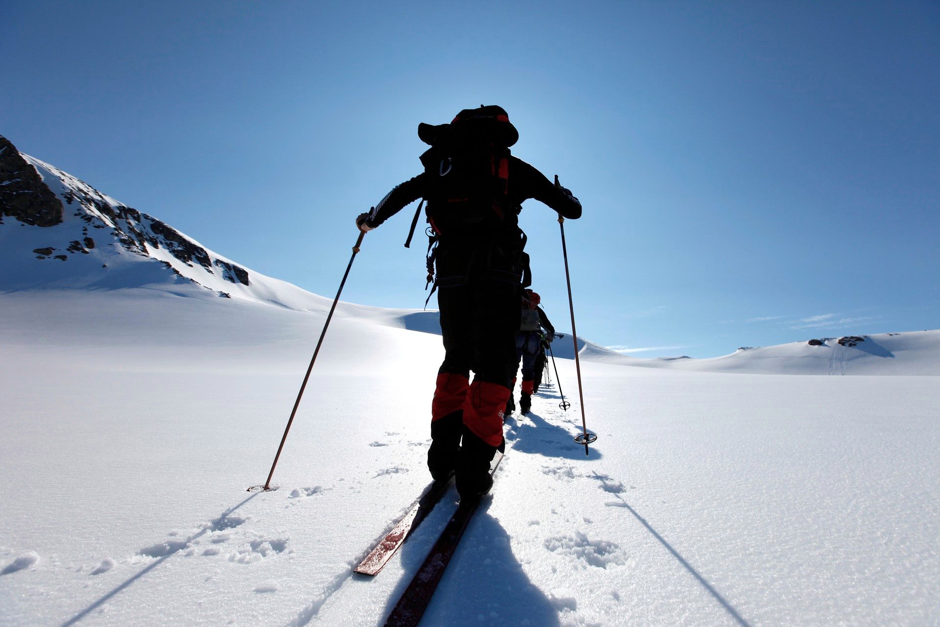 A person skiing facing the sun