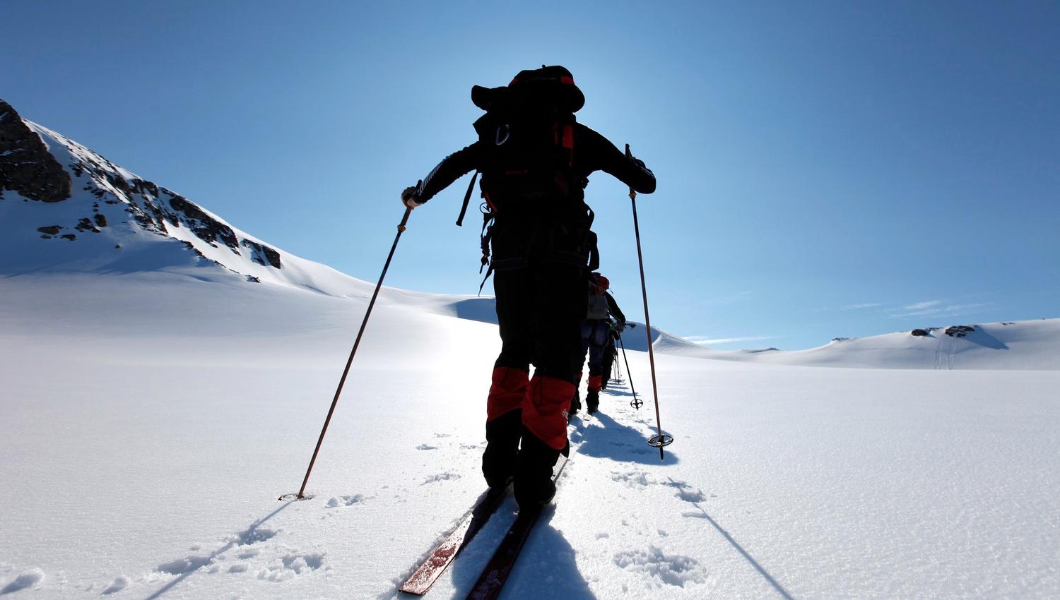 A person skiing facing the sun