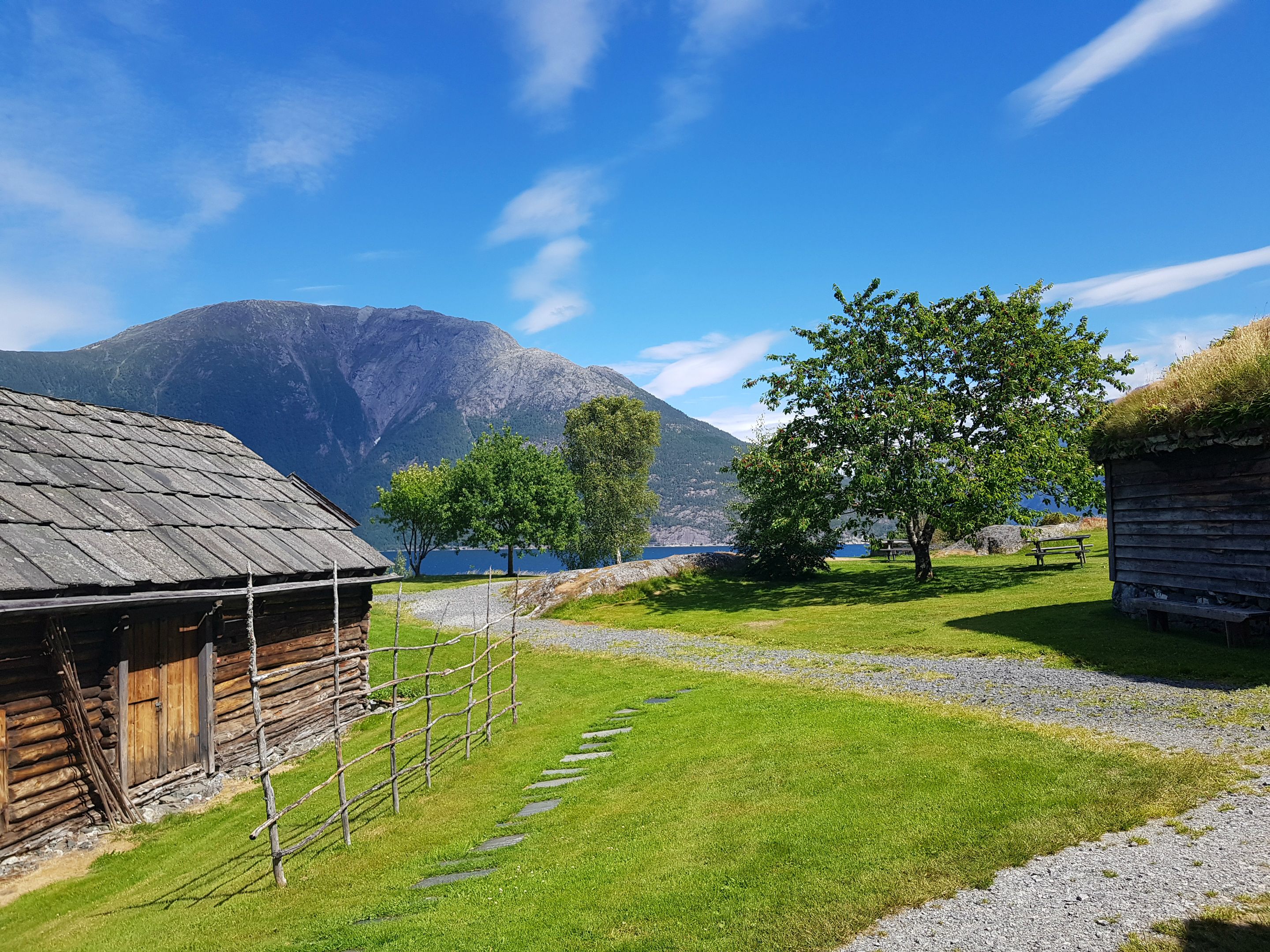 Vakkert tun med utsikt til fjord og fjell ved Hardanger folkemuseum.