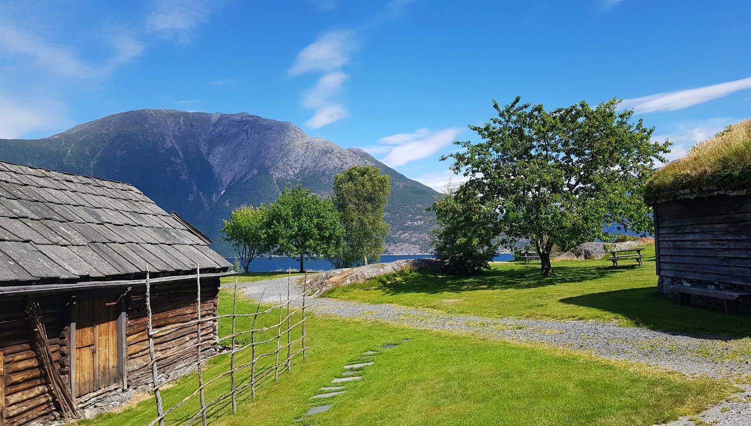 Vakkert tun med utsikt til fjord og fjell ved Hardanger folkemuseum.