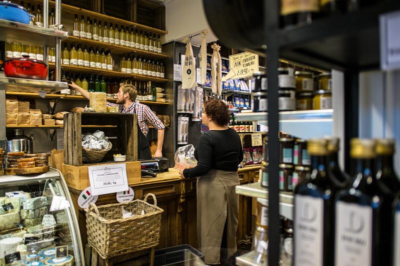 Ansatt som hjelper en kunde med olivenolje.