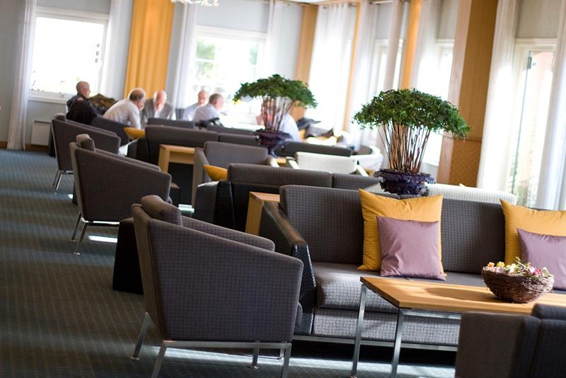 sofa og bord på rekke og rad i et pauseareal
