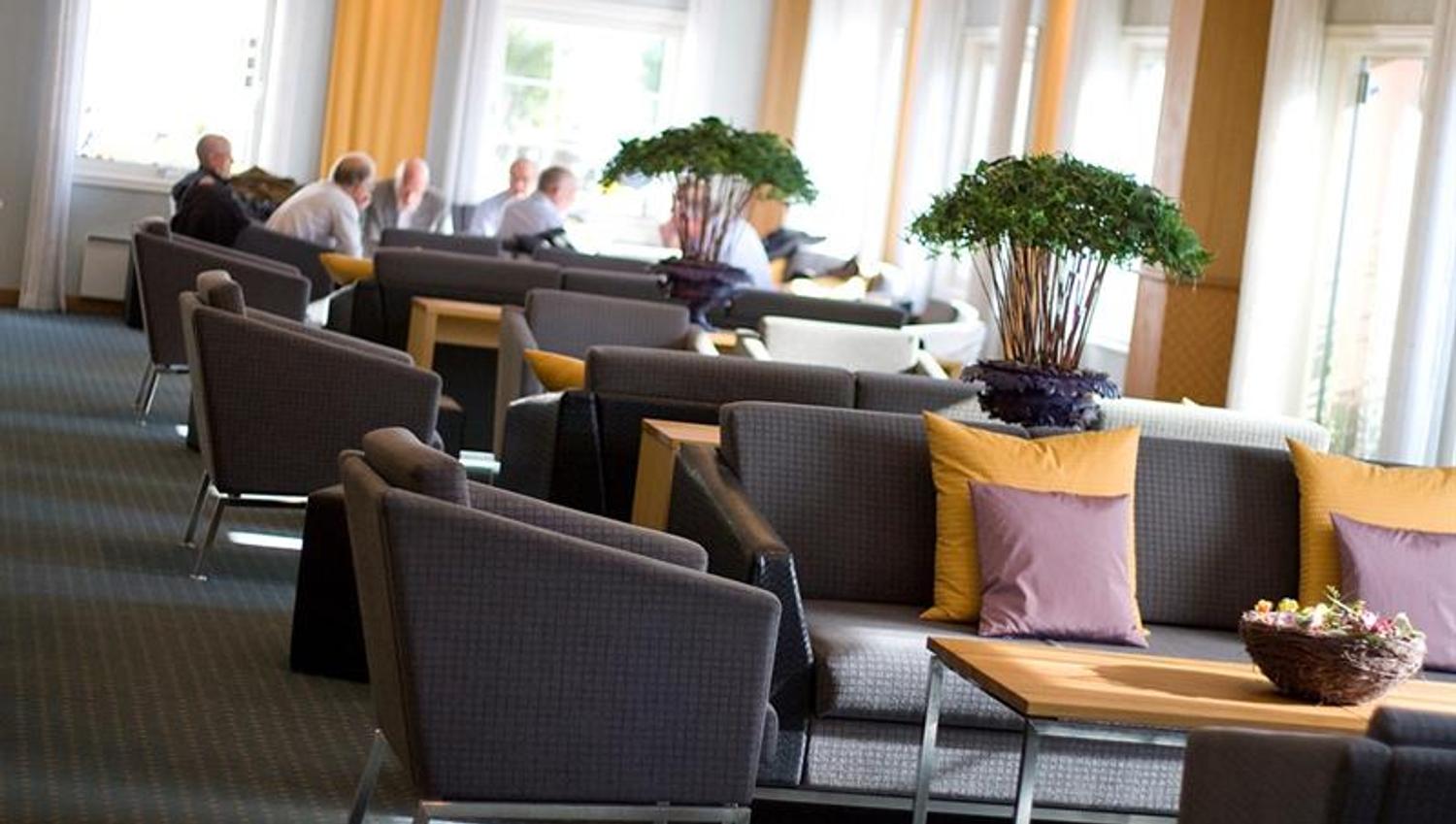 sofa og bord på rekke og rad i et pauseareal