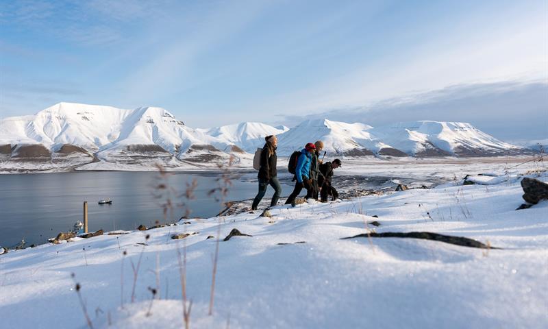 several people hiking up the snowcovered mountain 