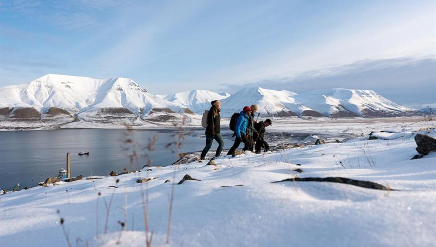 several people hiking up the snowcovered mountain