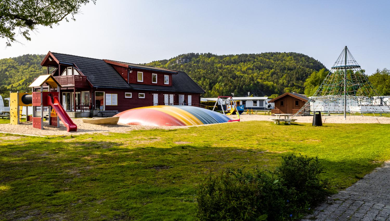 Solstrand Camping playground. A climbing tower in the center and a colorful jumping pillow beside it.