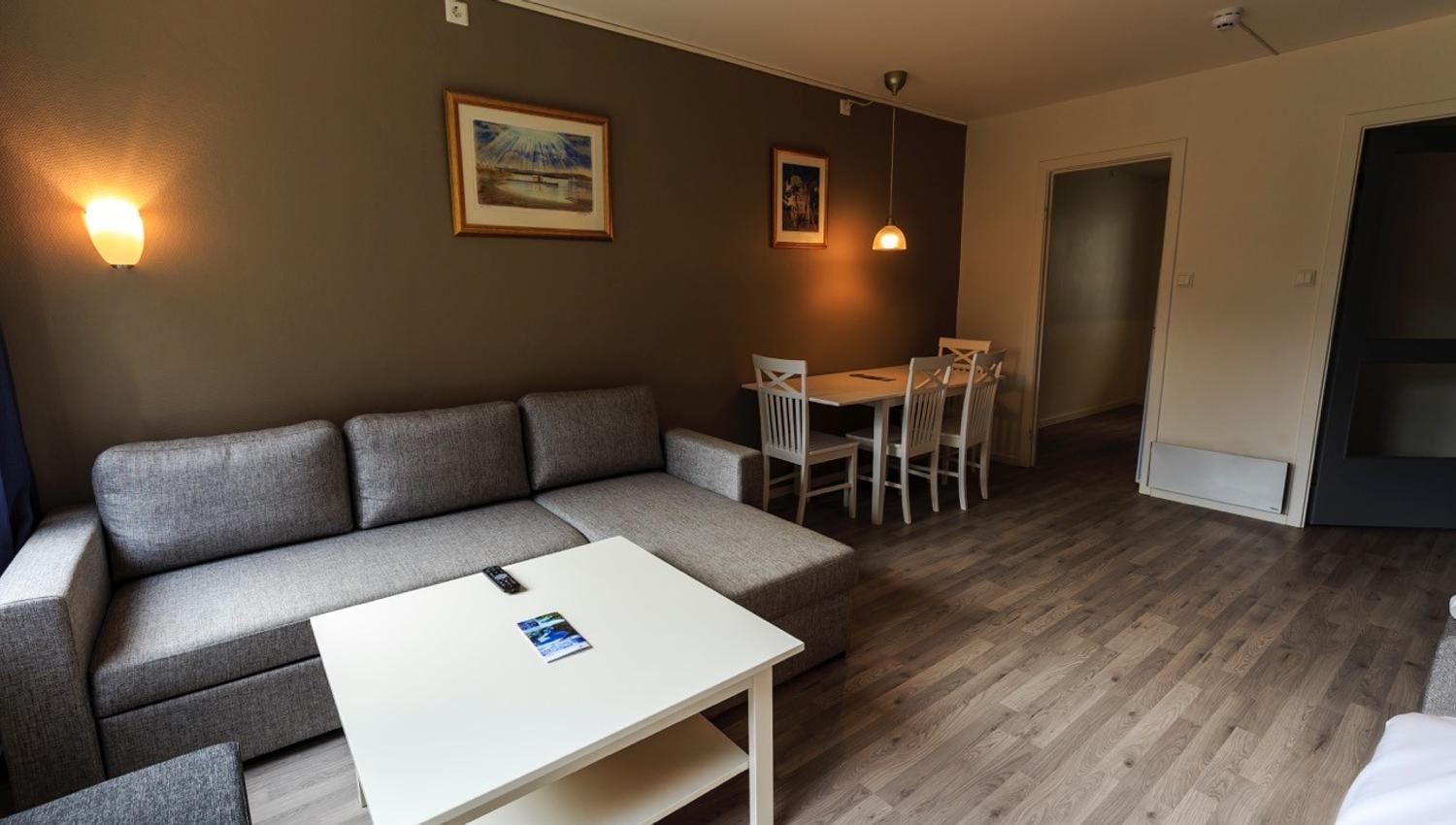 Cozy living area with sofa and dining table at Trolltunga Guesthouse – perfect for relaxing after a mountain hike.