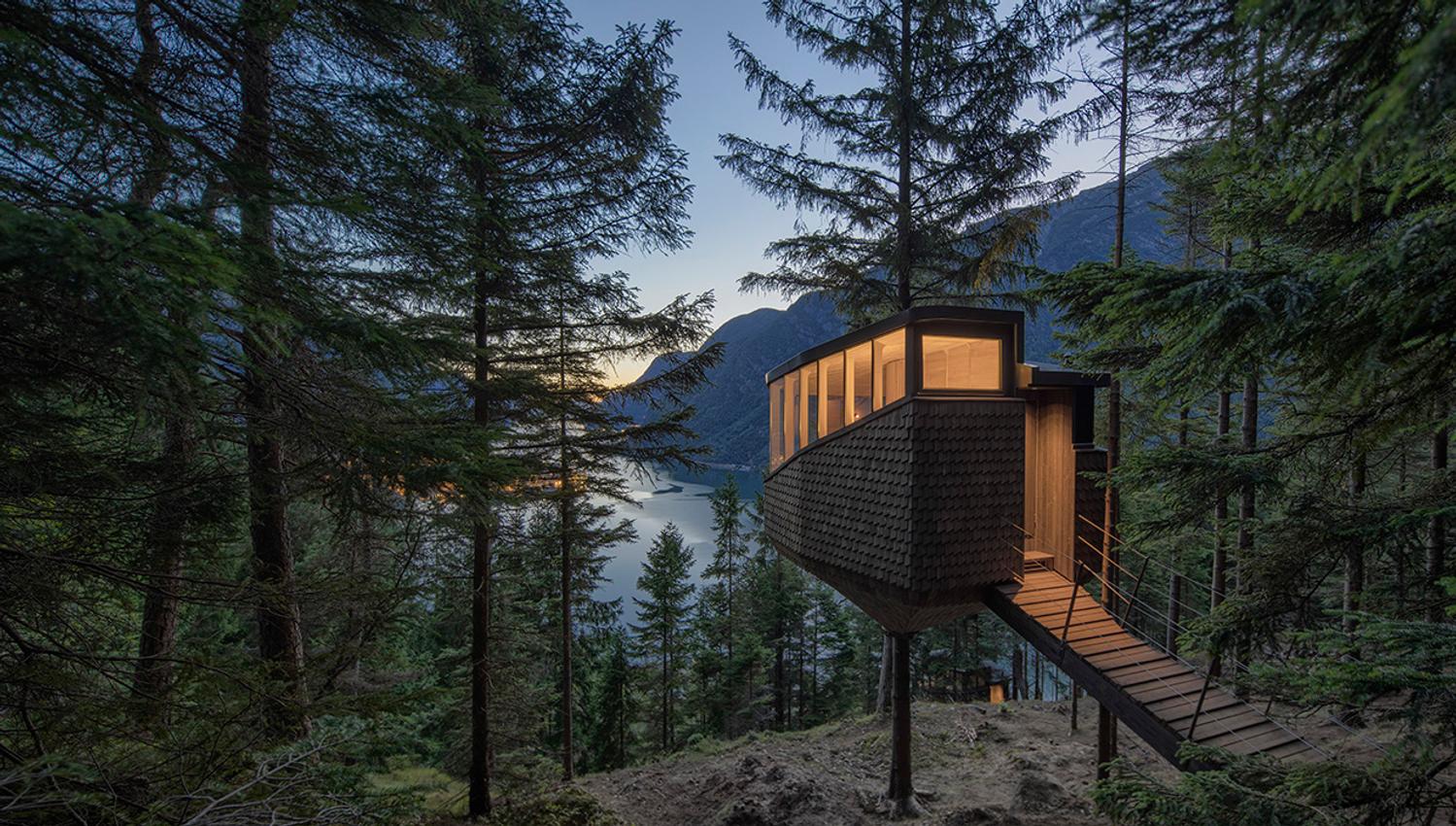 Woodnest tretopphytte i solnedgang – ein spektakulær plass å finne roen i naturen.