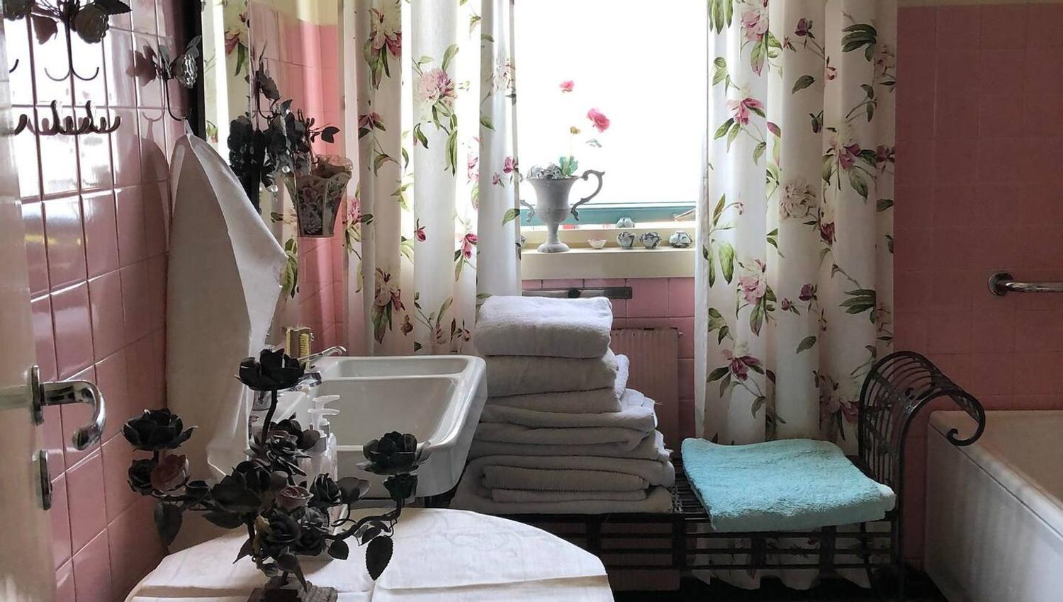 Flislagt rosa bad med håndduker