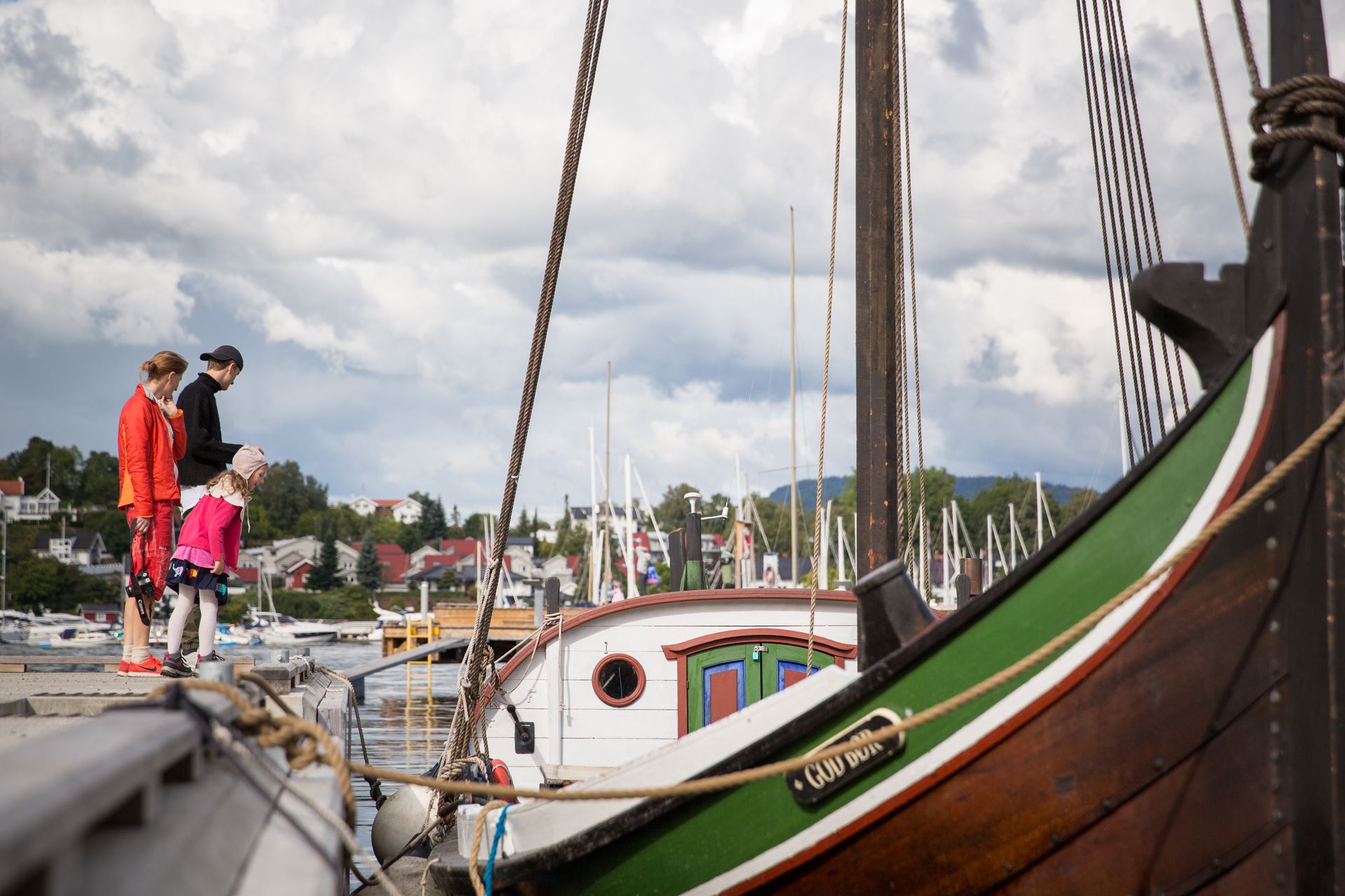 Family on the pier, wooden boat
