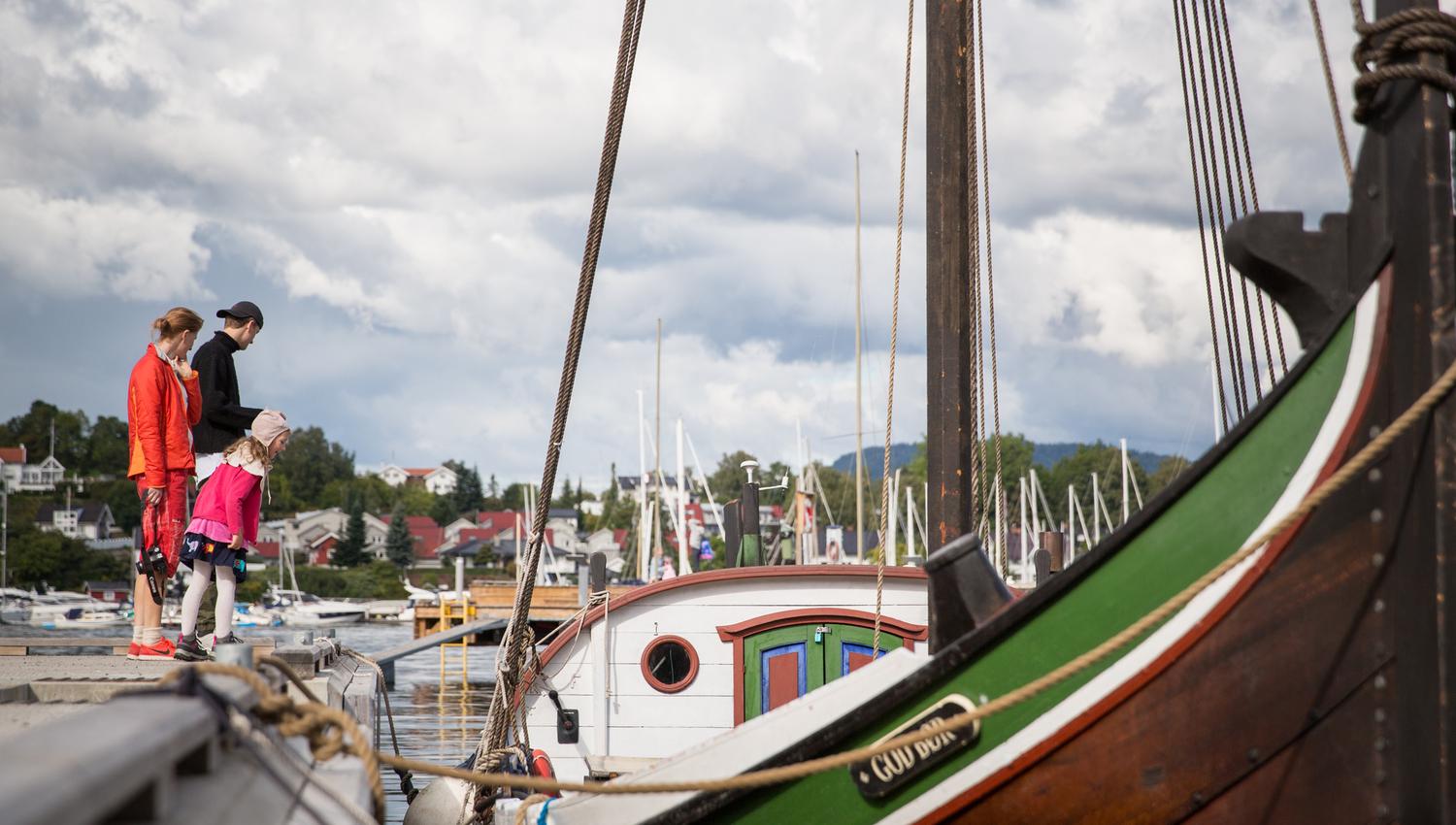 Family on the pier, wooden boat