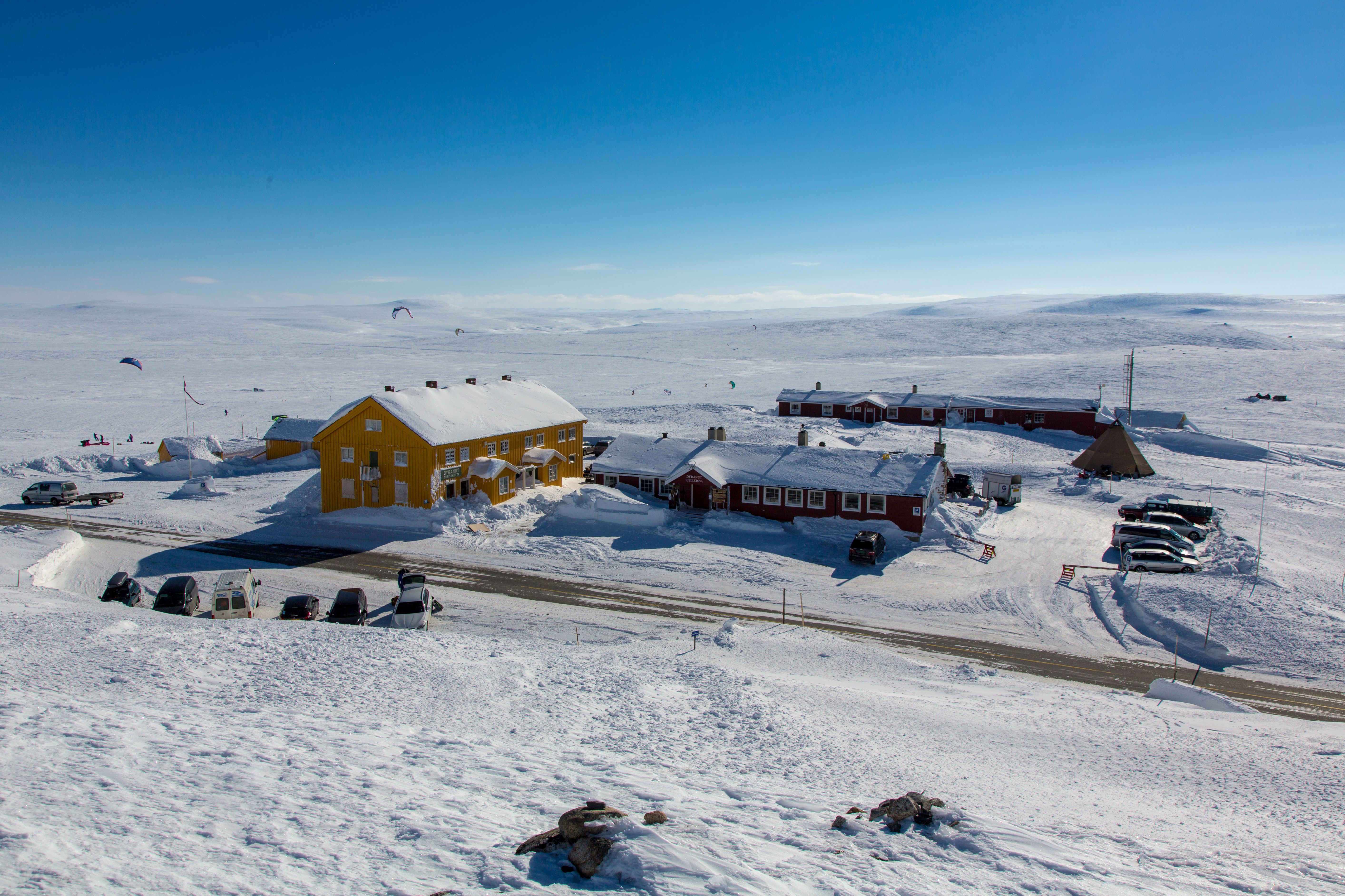 Den røde Dyranut Fjellstova og gule Dyranut Turisthytta i snølandskap.