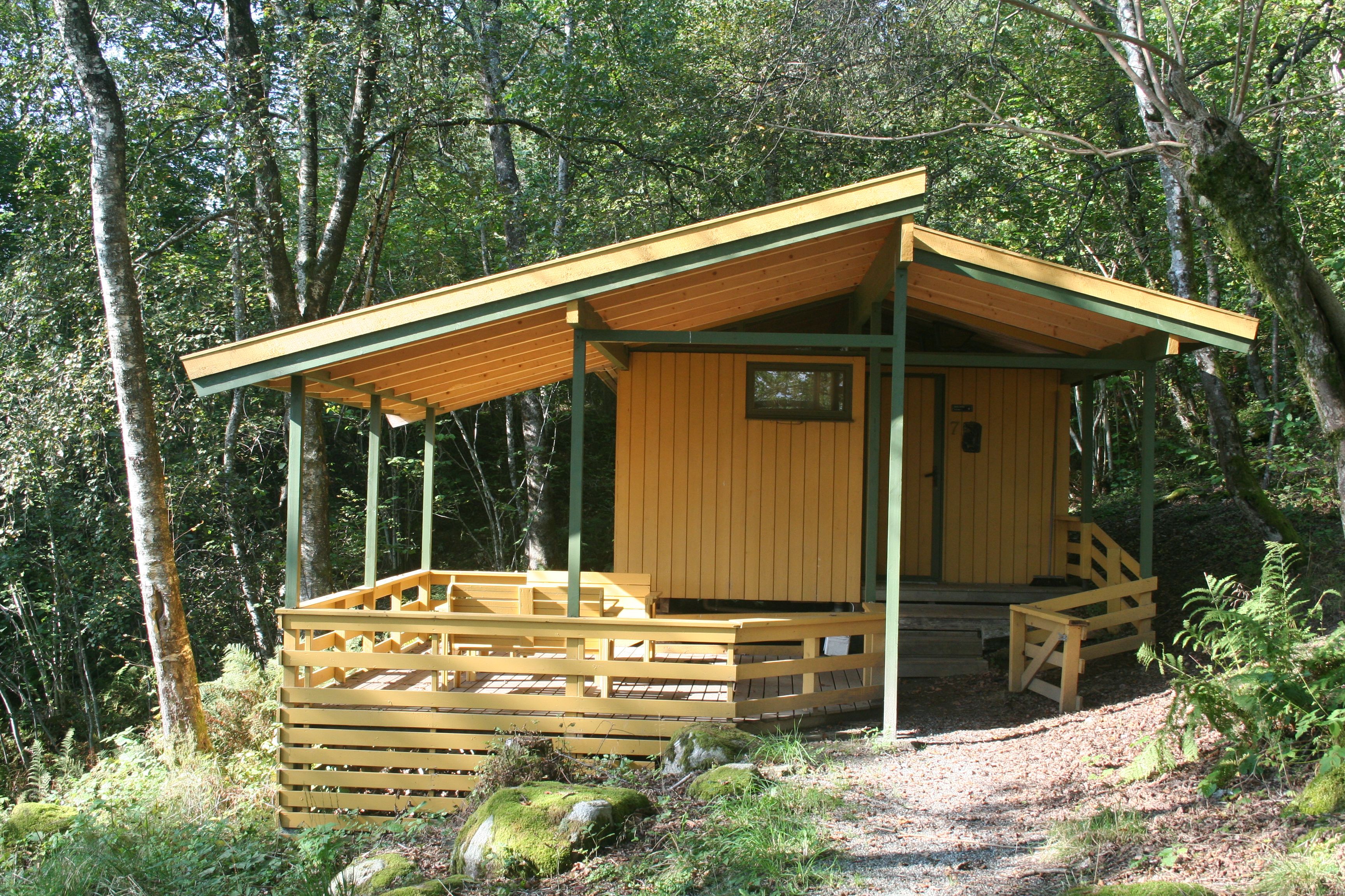 Gule hytter i skogen på Hardanger Feriesenter, fredfull atmosfære.