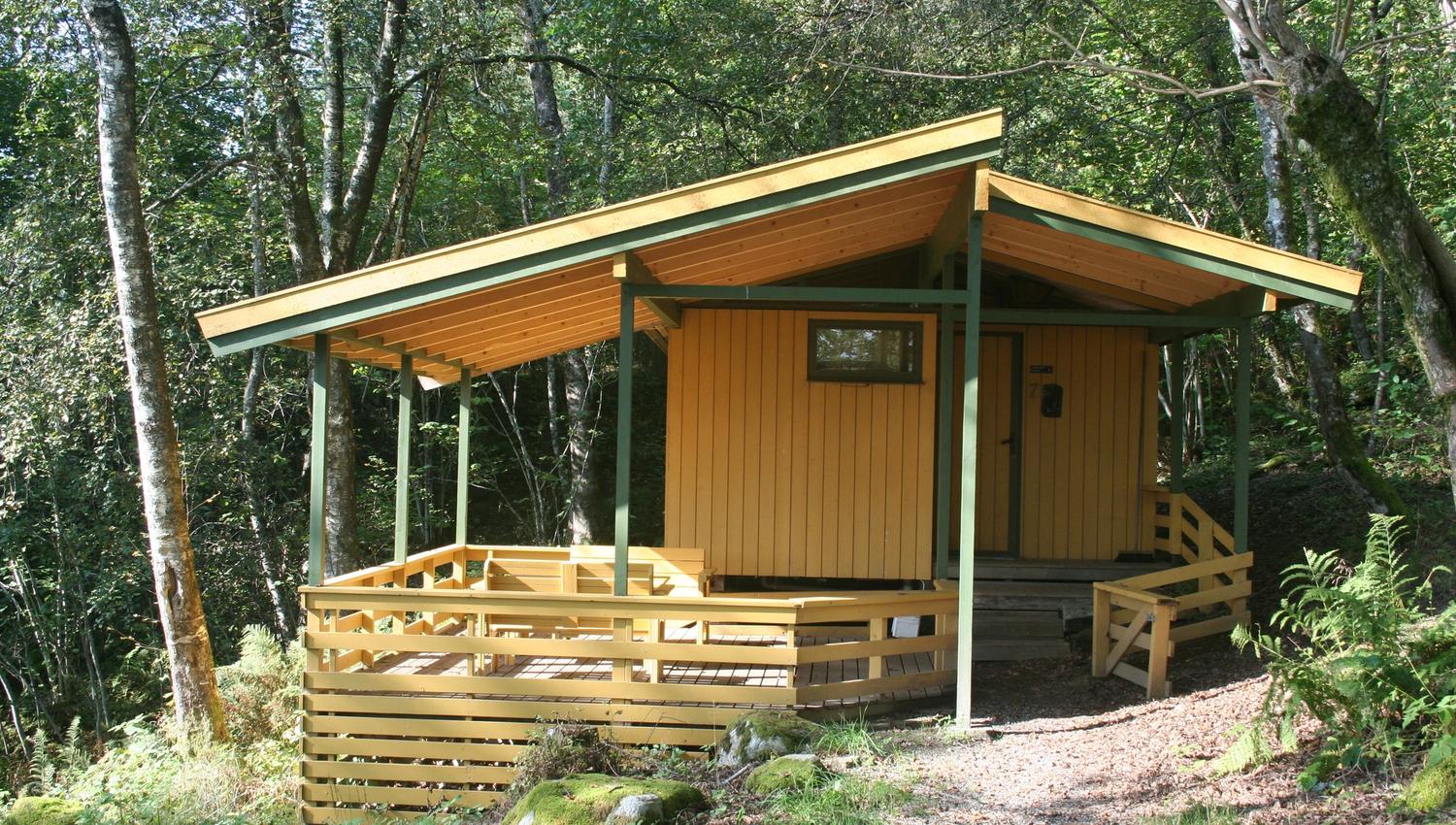 Gule hytter i skogen på Hardanger Feriesenter, fredfull atmosfære.