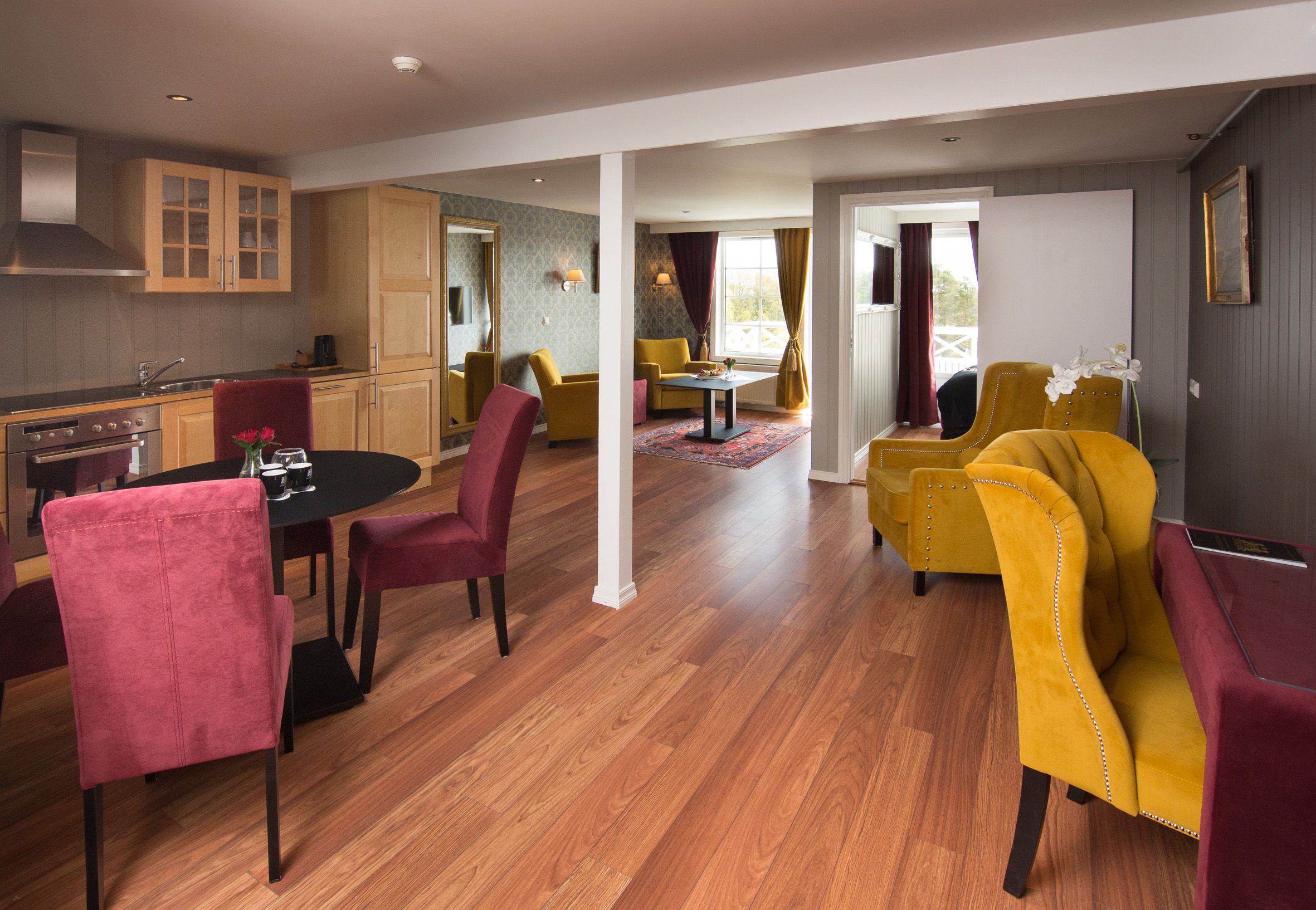 stue i hotellet med gule og vinrøde ørelappstoler