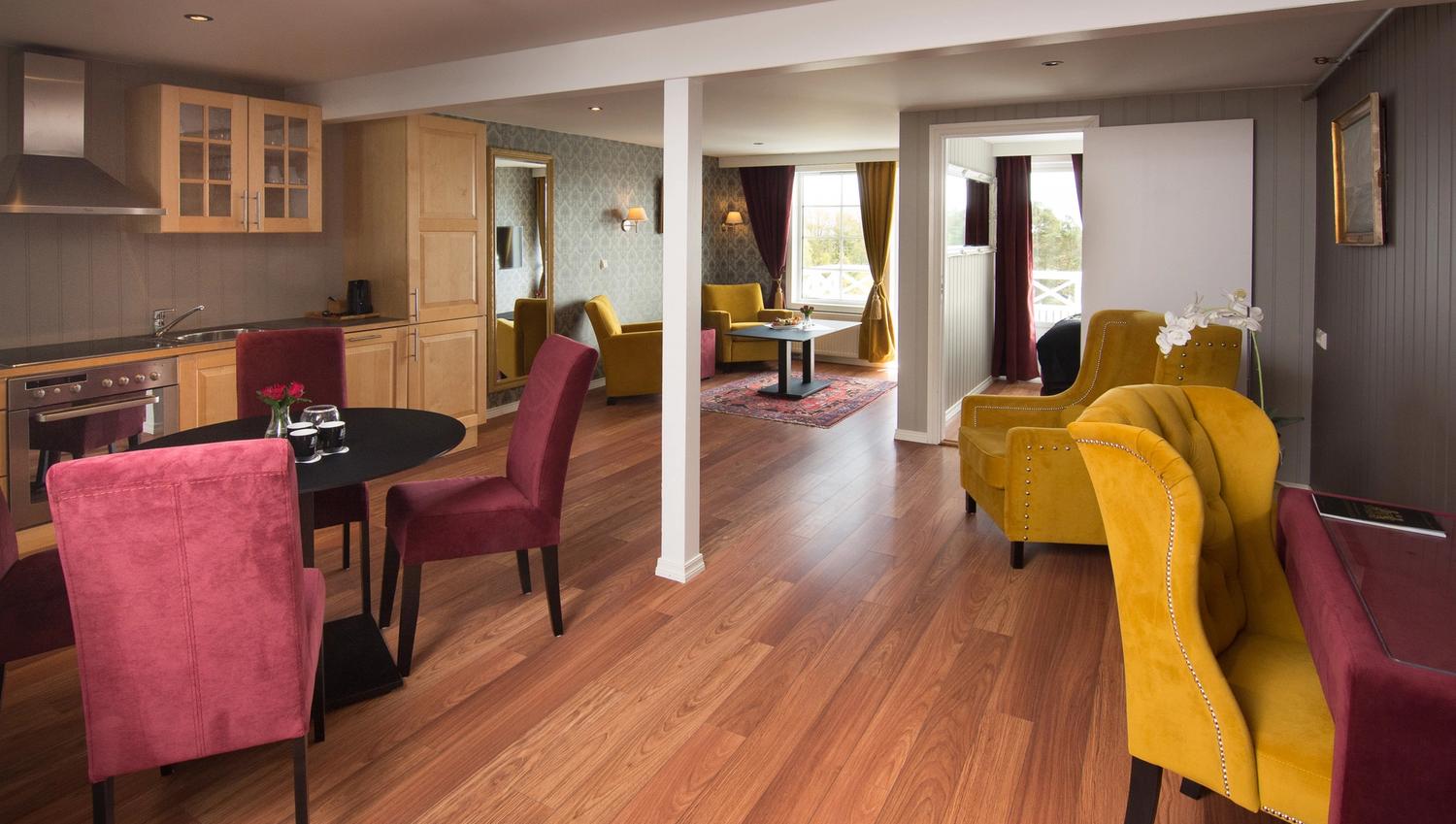 stue i hotellet med gule og vinrøde ørelappstoler