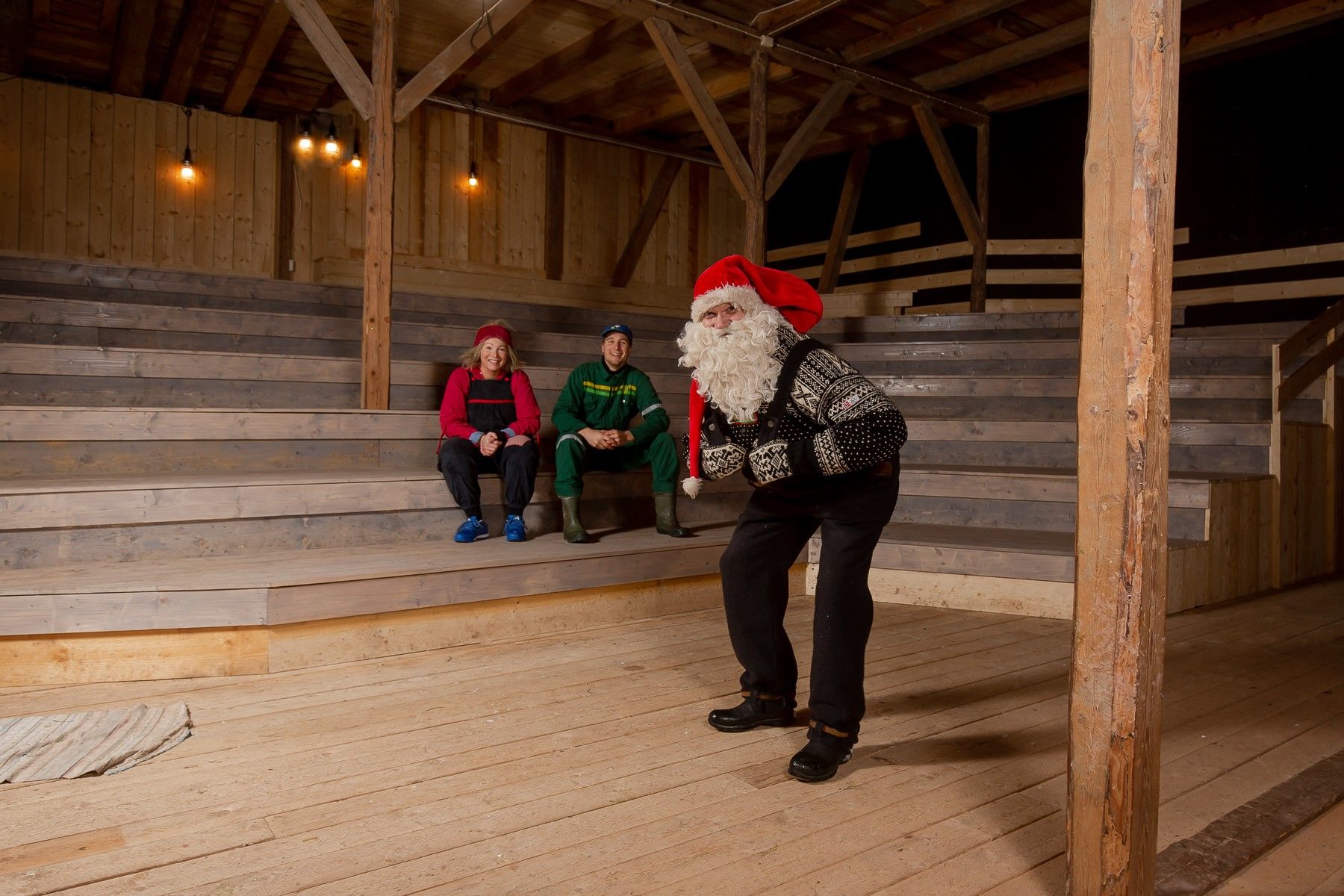 Santa is rehearsing the stage, two other actors are sitting in the stands