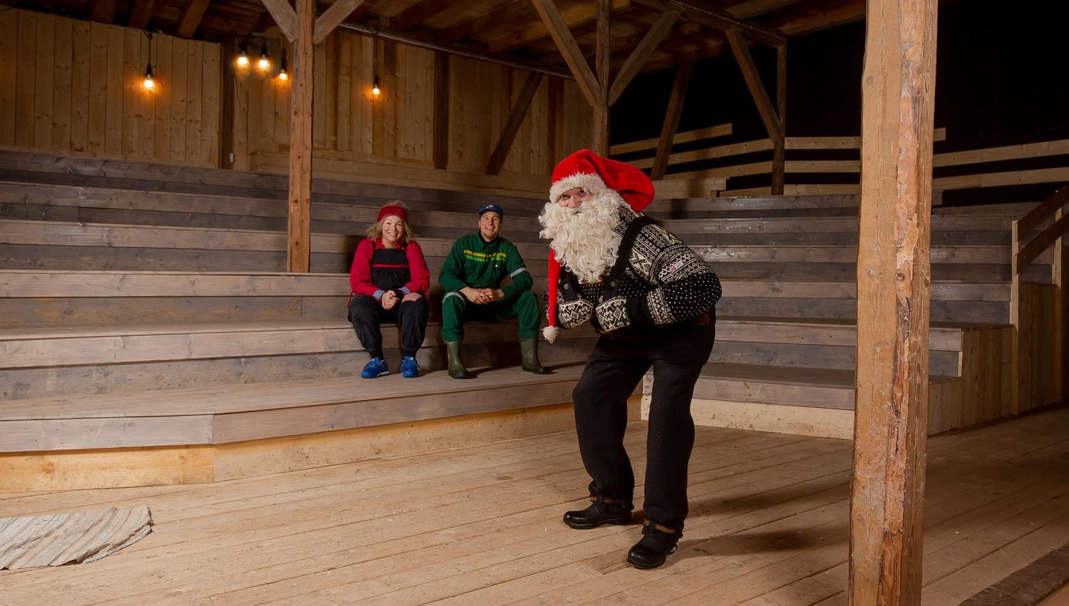 Santa is rehearsing the stage, two other actors are sitting in the stands