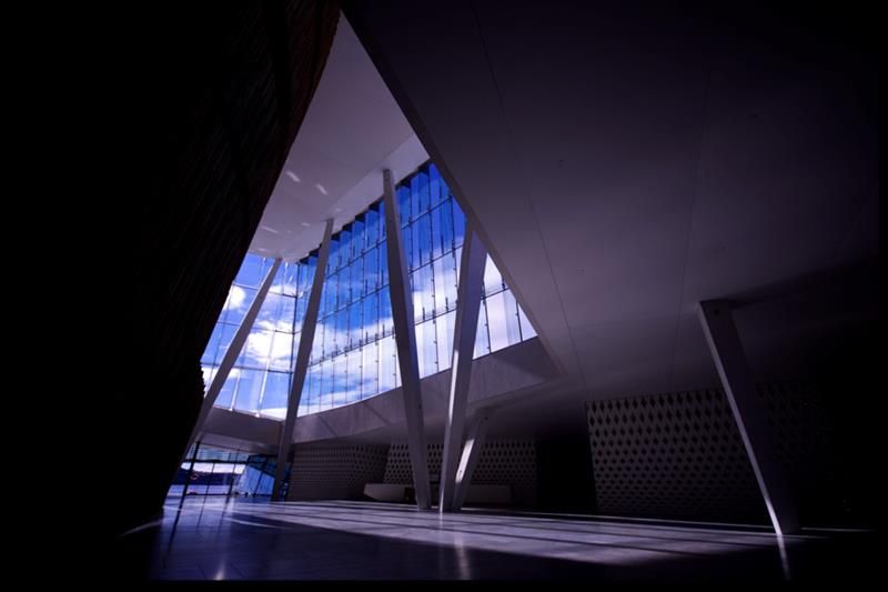 Interiørbilde av høyt tak med store glassvinduer.