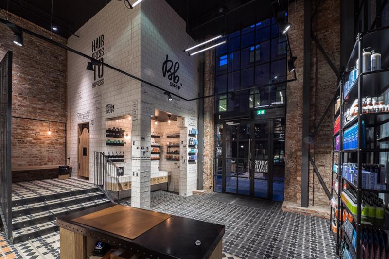 Butikkinteriør med mursteinsvegger og høyt tak.