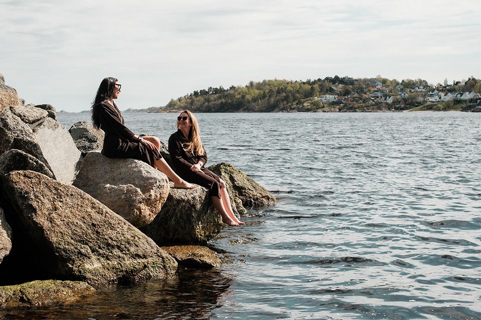 to damer sitter i vannkanten