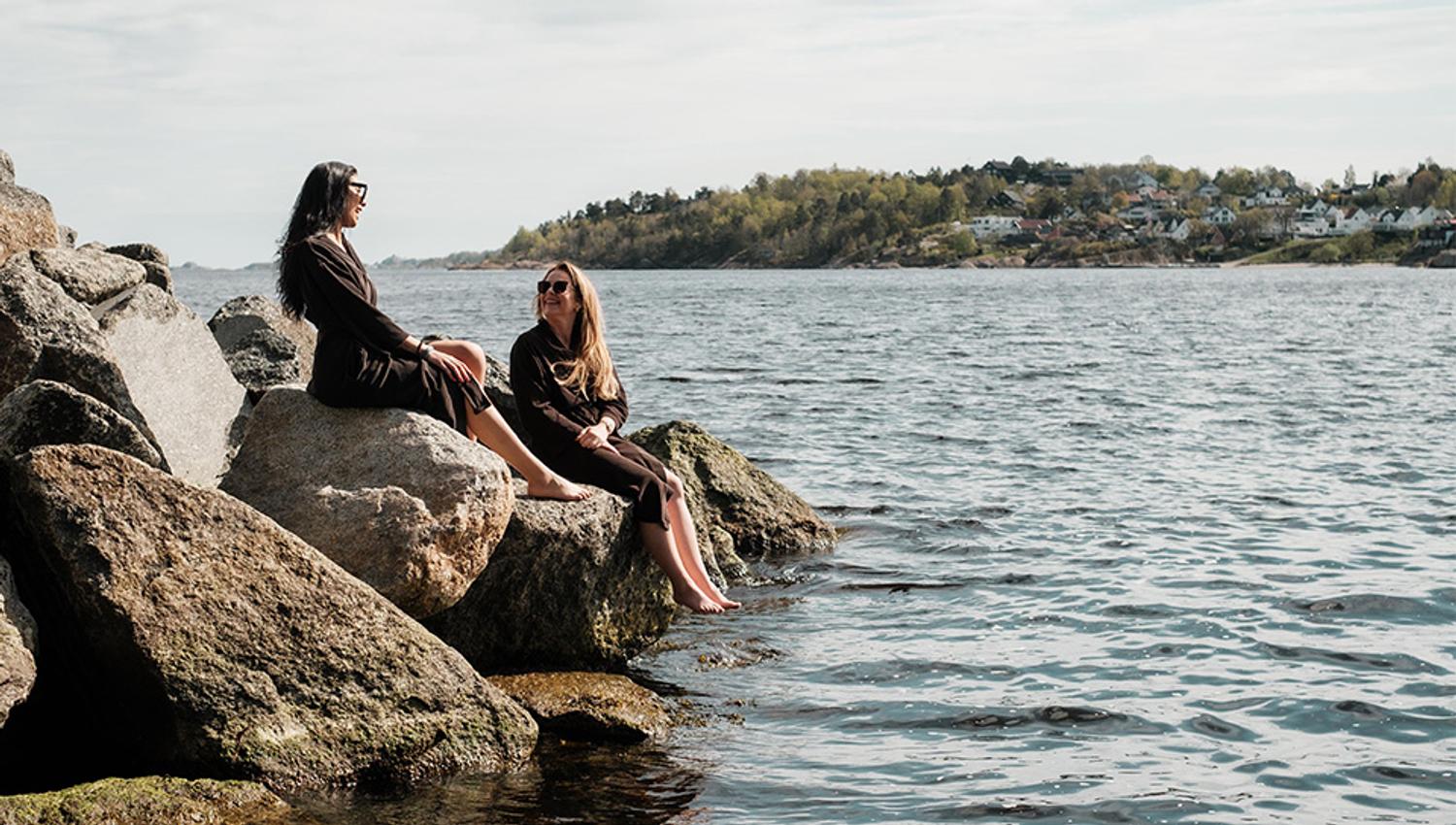to damer sitter i vannkanten