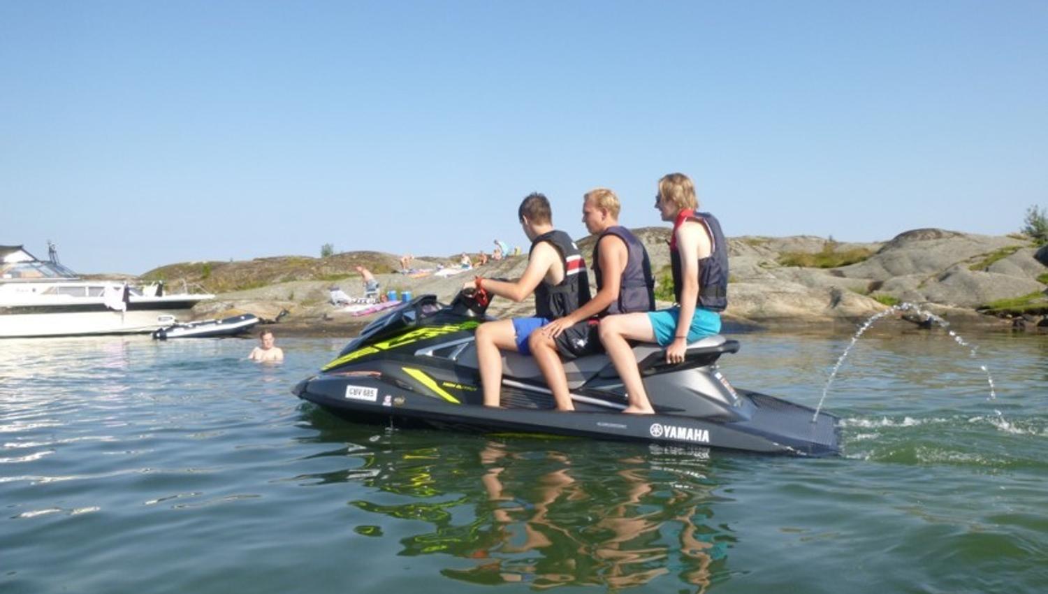 tre menn på en vannscooter