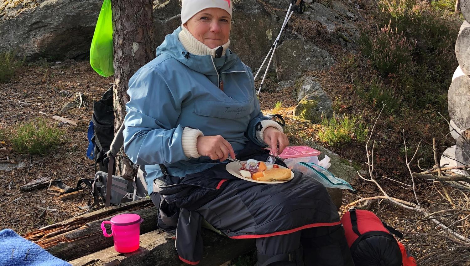 Dame som spiser mat i skogen