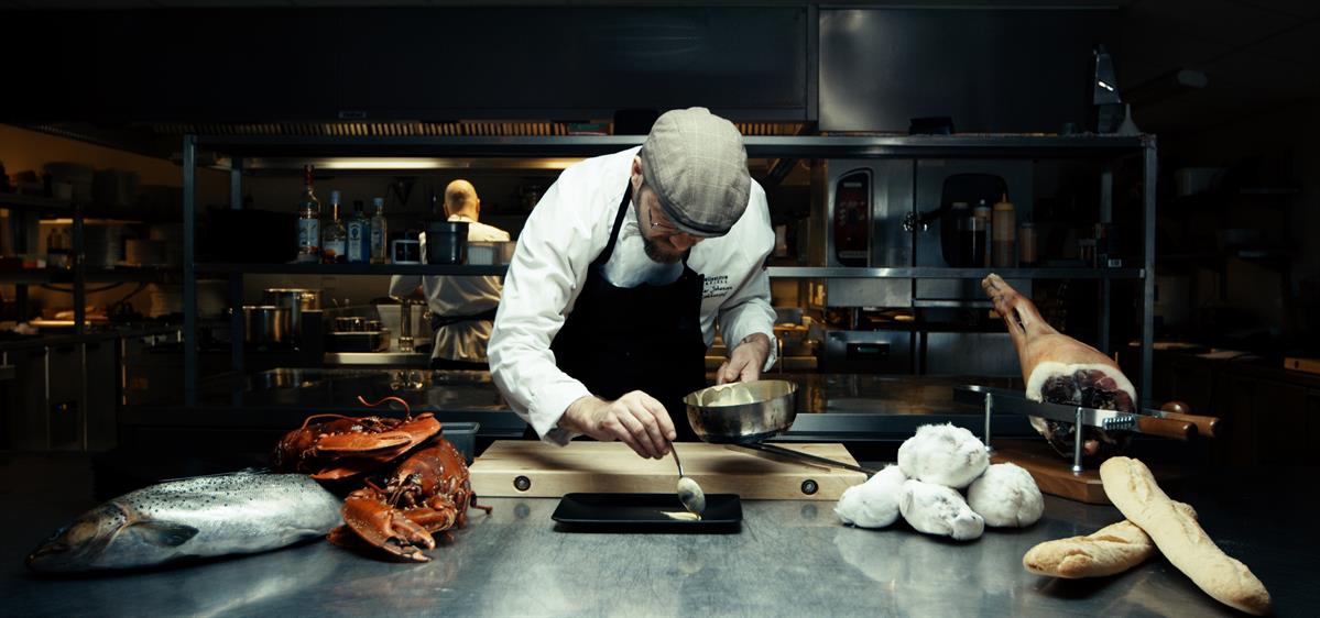 Kokken legger mat på tallerken som skal ut til en gjest på Pellestova Restaurant